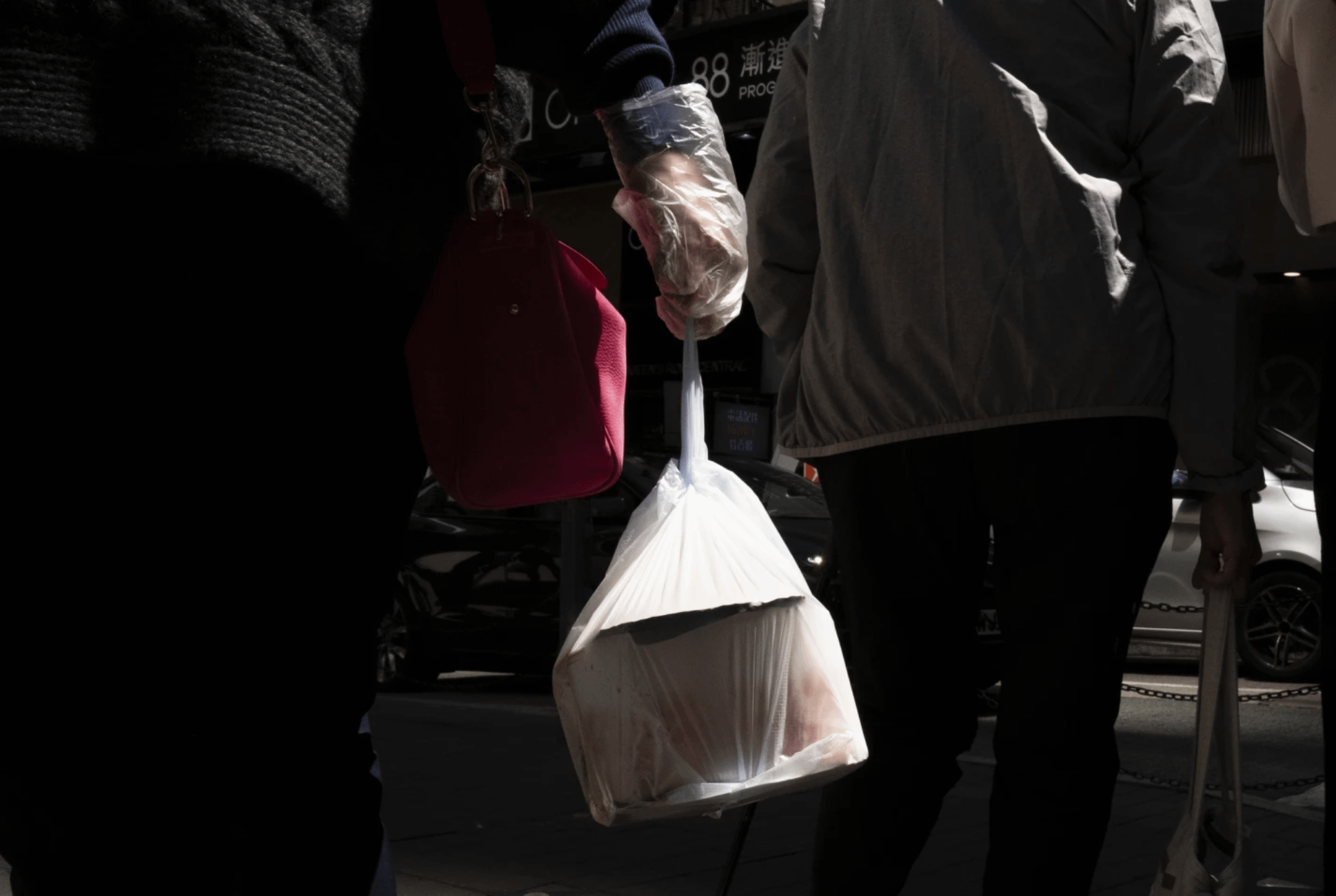 全球塑膠年產量預計到2060年達到10億噸，其中大多數是一次性塑膠，如飲料瓶與速食容器。圖為香港街頭一位婦人拎著一袋塑膠餐具外食（美聯社）