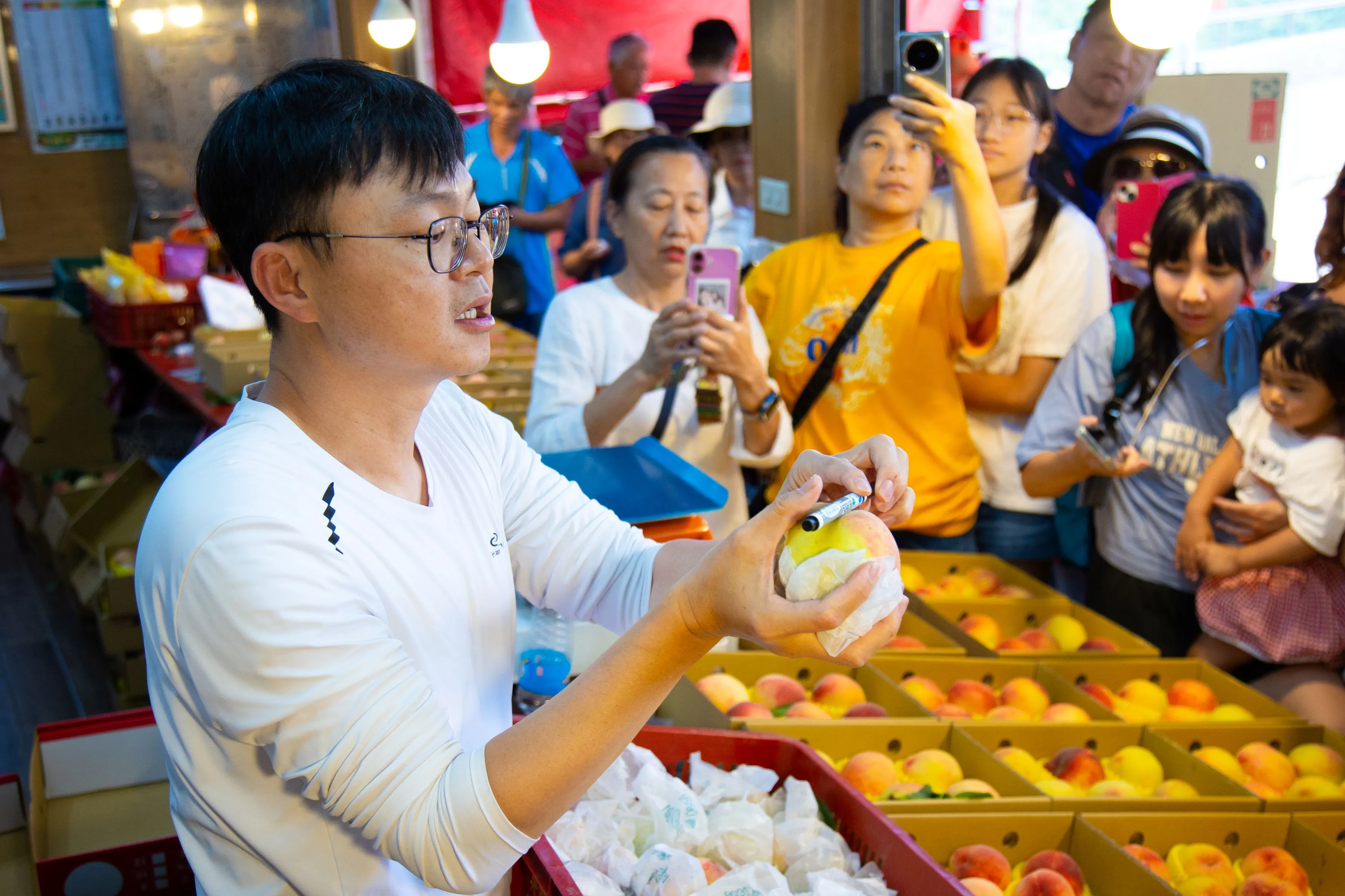 探索北橫夏季活動的放鬆採果之旅，農園園主介紹水蜜桃的採摘訣竅，遊客專注聆聽。（圖／桃園市政府風景區管理處）