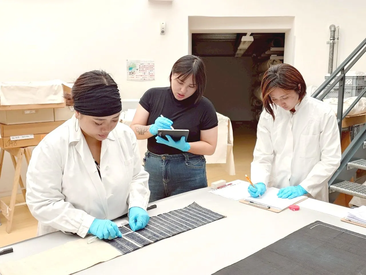 考察團於維也納世界博物館內進行藏品測量，新北市原民局長Siku Yaway 林瑋茜也共同進入庫房參與調研工作(右1)。(圖/新北市原民局提供)