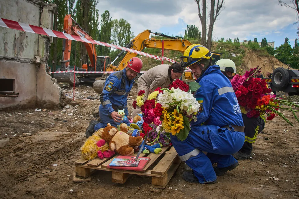 2025年8月1日、ウクライナのキエフで、救助隊がロシアの空襲現場においておもちゃと花を捧げた。空襲は31名の市民死亡をもたらし、その中には5名の子供も含まれた。(AP通信)