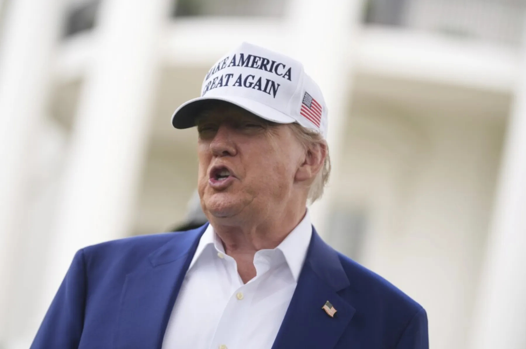 美國總統川普頭戴「讓美國再次偉大」(Make America Great Again)的白色棒球帽。(美聯社)