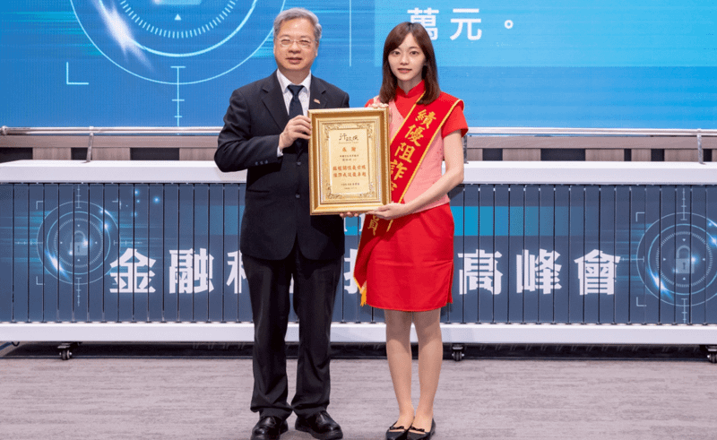 中信銀行孫姓同仁（右）阻詐有成，由行政院秘書長龔明鑫（左）頒發「臨櫃攔阻績優之金融從業人員」殊榮。（圖/中信銀行提供）