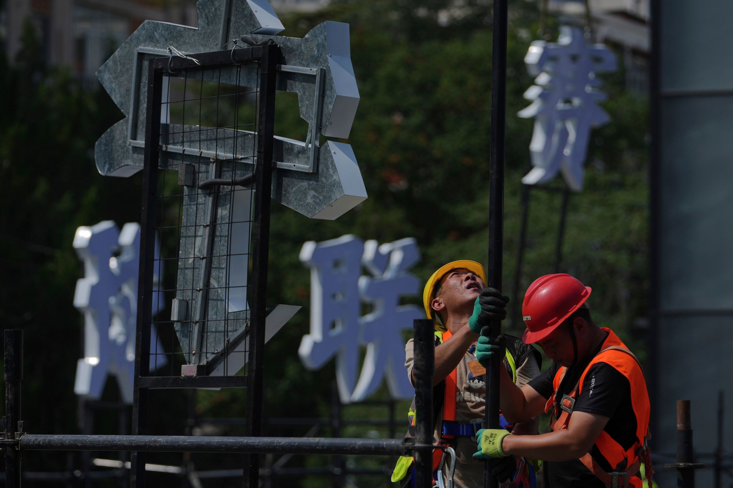 2025年8月6日，北京，工人在市中心商業區搭建中國體育品牌李寧即將舉辦的籃球賽活動平台。（美聯社）