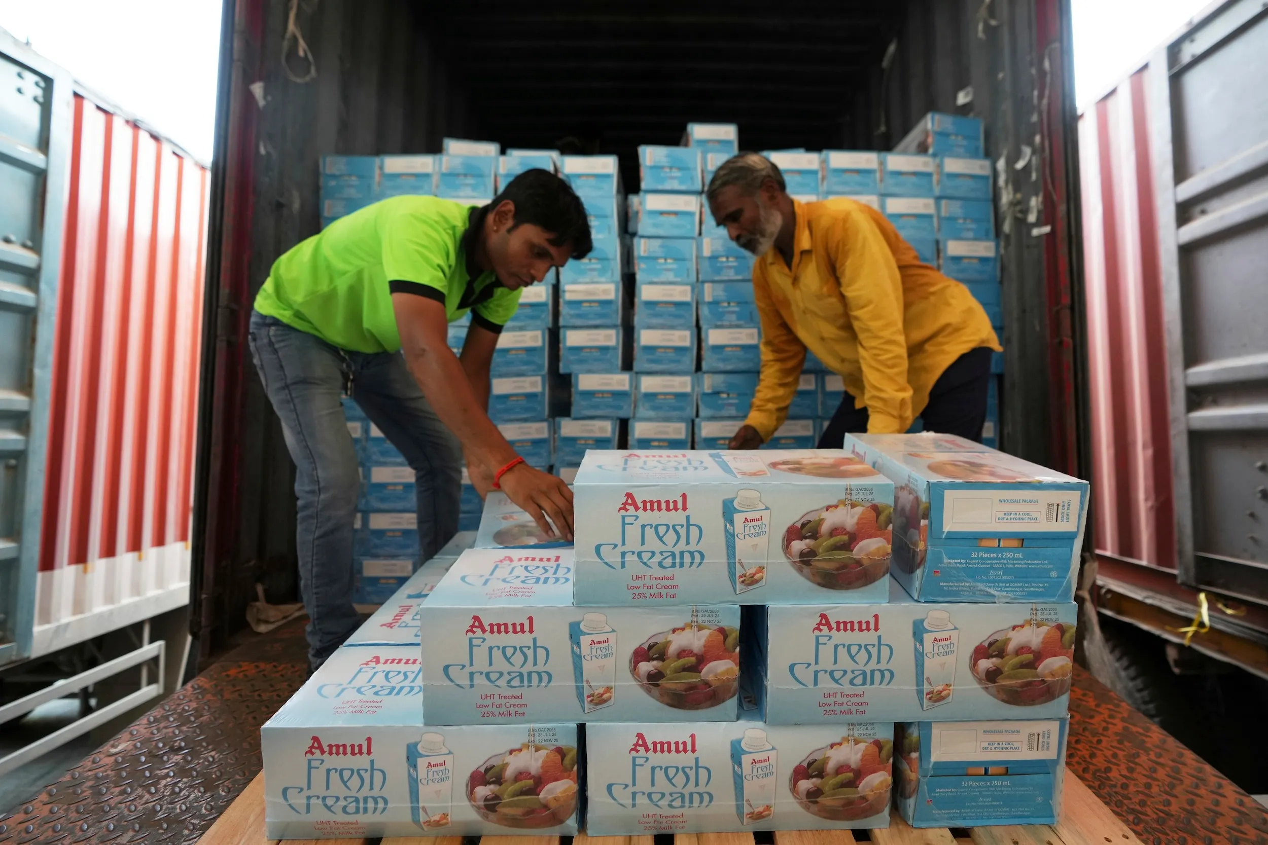 2025年8月7日，印度甘地納加（Gandhinagar）AmulFed乳品廠，工人將奶油包裝裝入貨櫃。（美聯社）