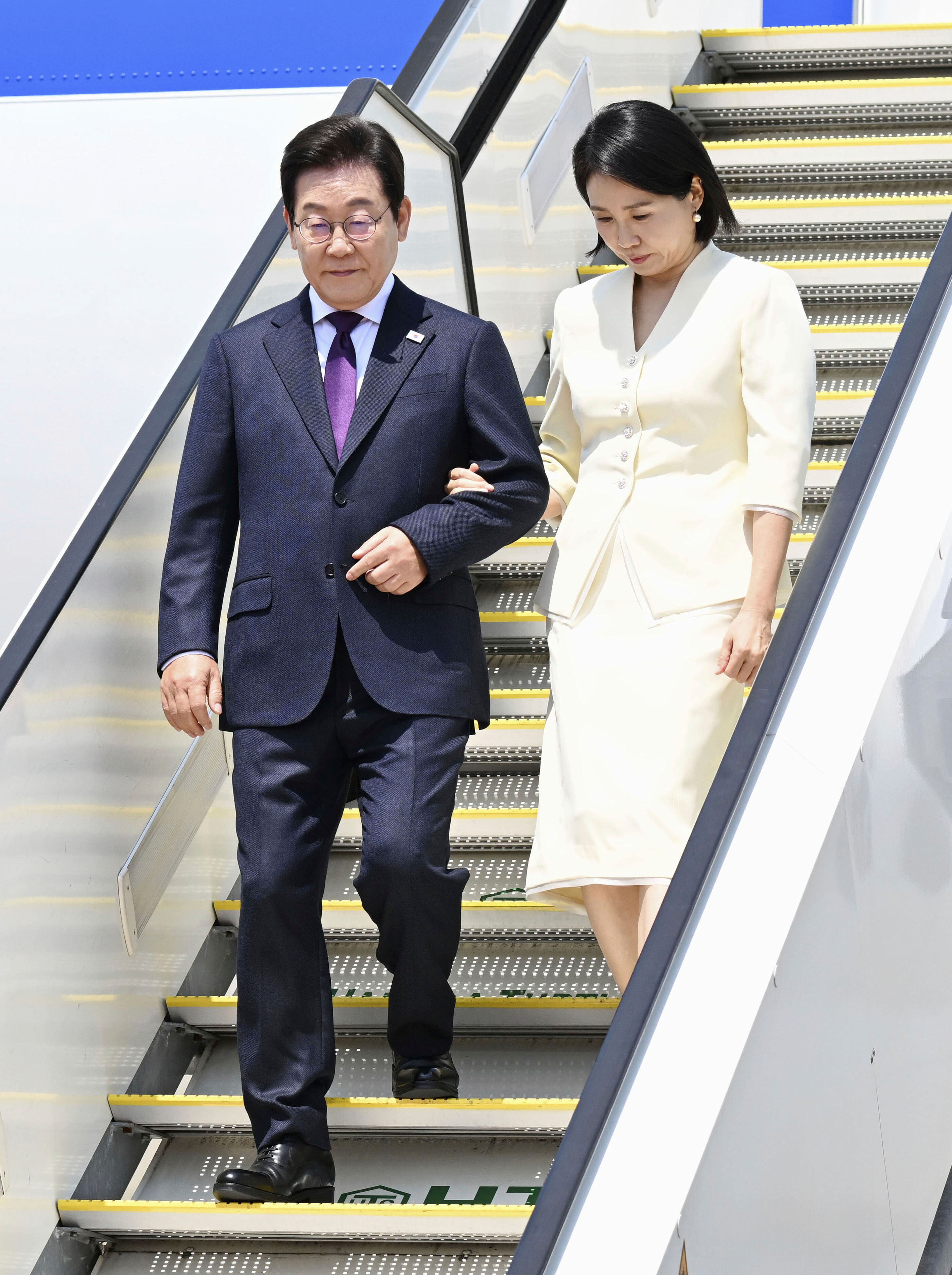 8月23日，韓國總統李在明（左）和夫人金喜慶（右）抵達日本東京羽田機場。 (AP)