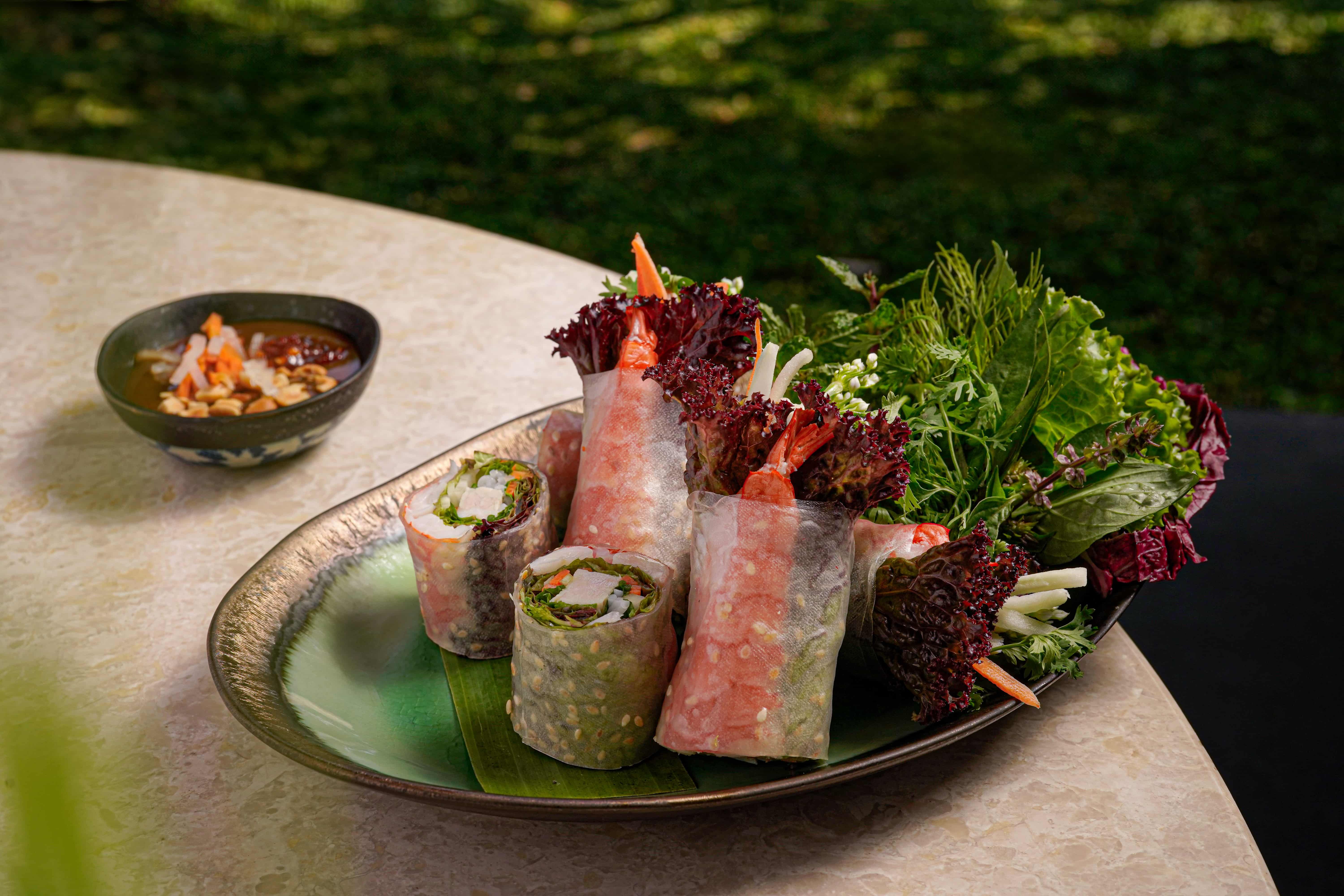 「味遊富國島」客座活動的菜色中的西貢生春捲，是以米紙包裹虎蝦、豬五花、米線及多種新鮮蔬菜香草，以冰涼狀態上桌後佐以越南特有的魚露沾醬（nước chấm）、花生醬或豆豉醬享用，十足消暑開胃。(圖/台北晶華提供)