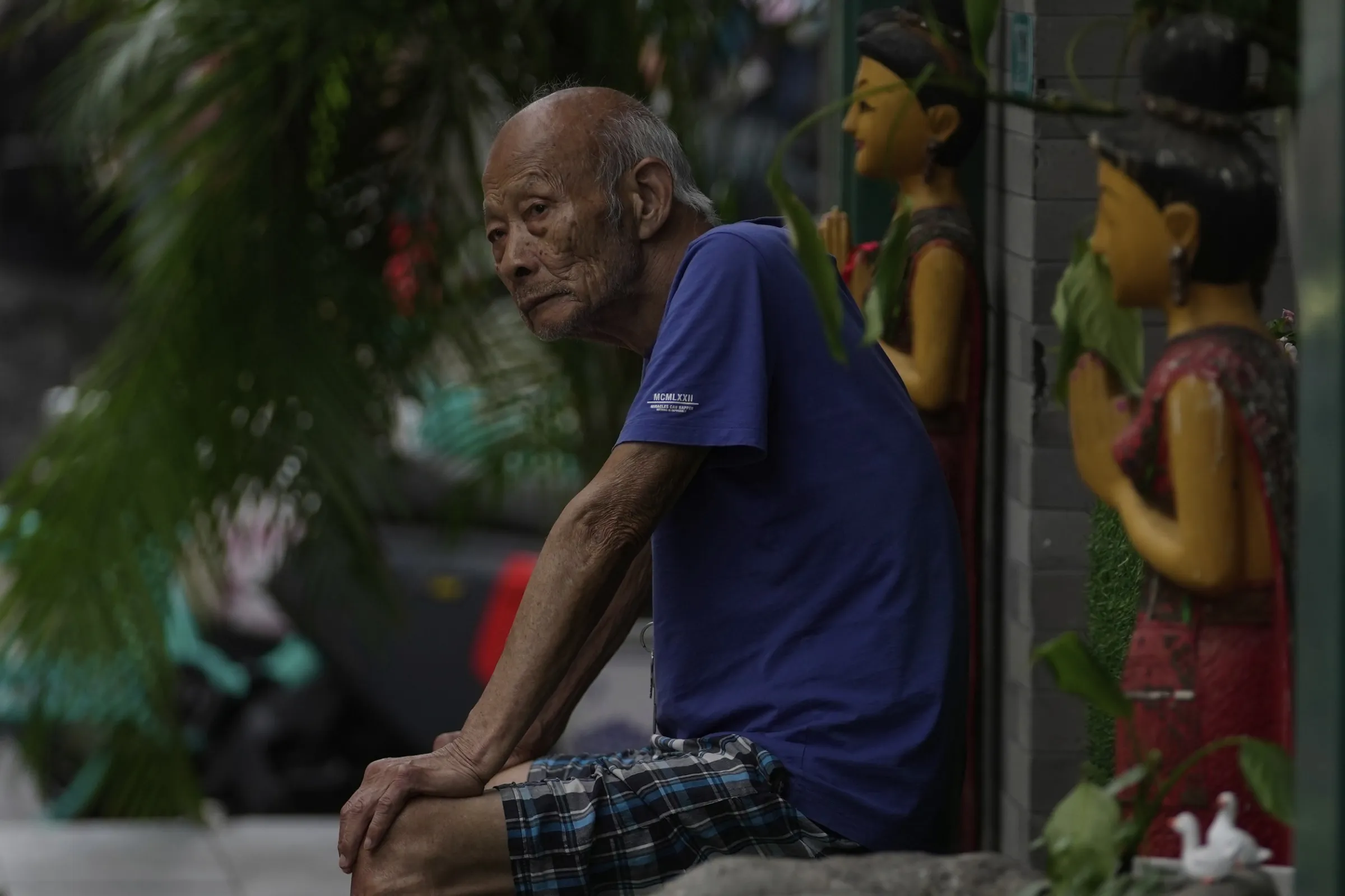 2025年8月24日，中國北京，一名年長男子坐在前門大街一間商店外休息。（美聯社）