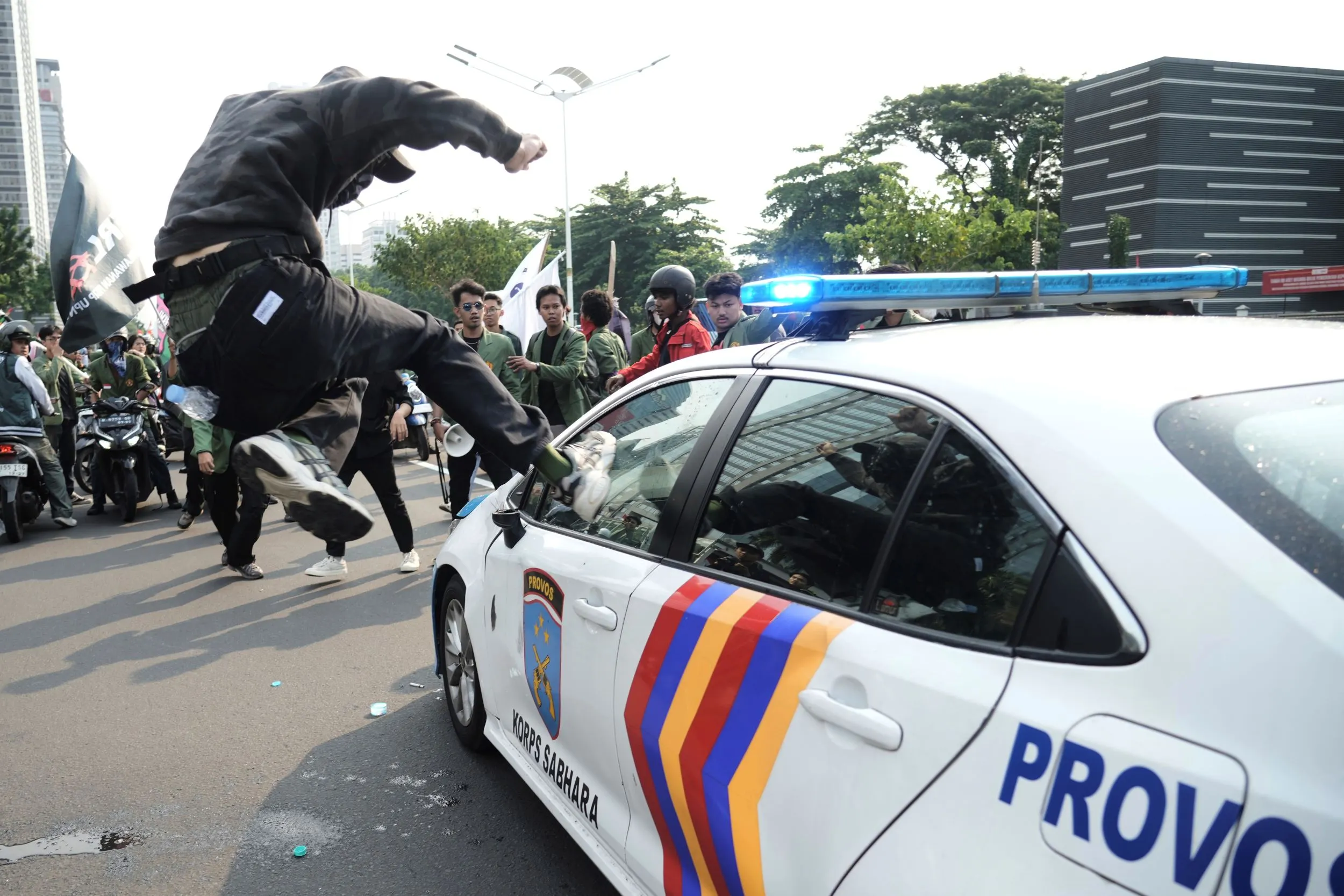 インドネシアの首都ジャカルタで激しいデモが発生し、民衆が警察車両を棒で破壊する。（AP通信）