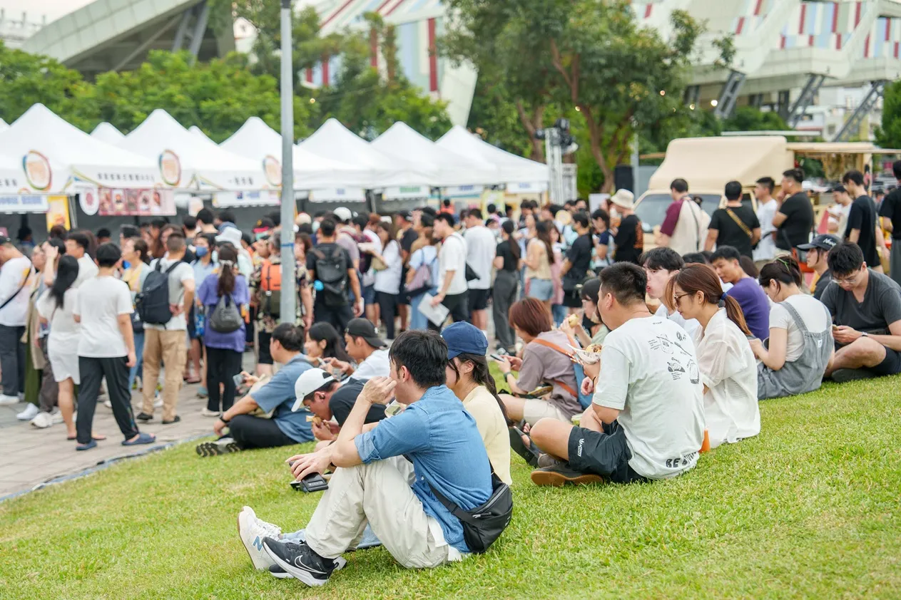 現場民眾野餐坐在草地上野餐，享受美味。（圖／臺北市政府商業處提供）