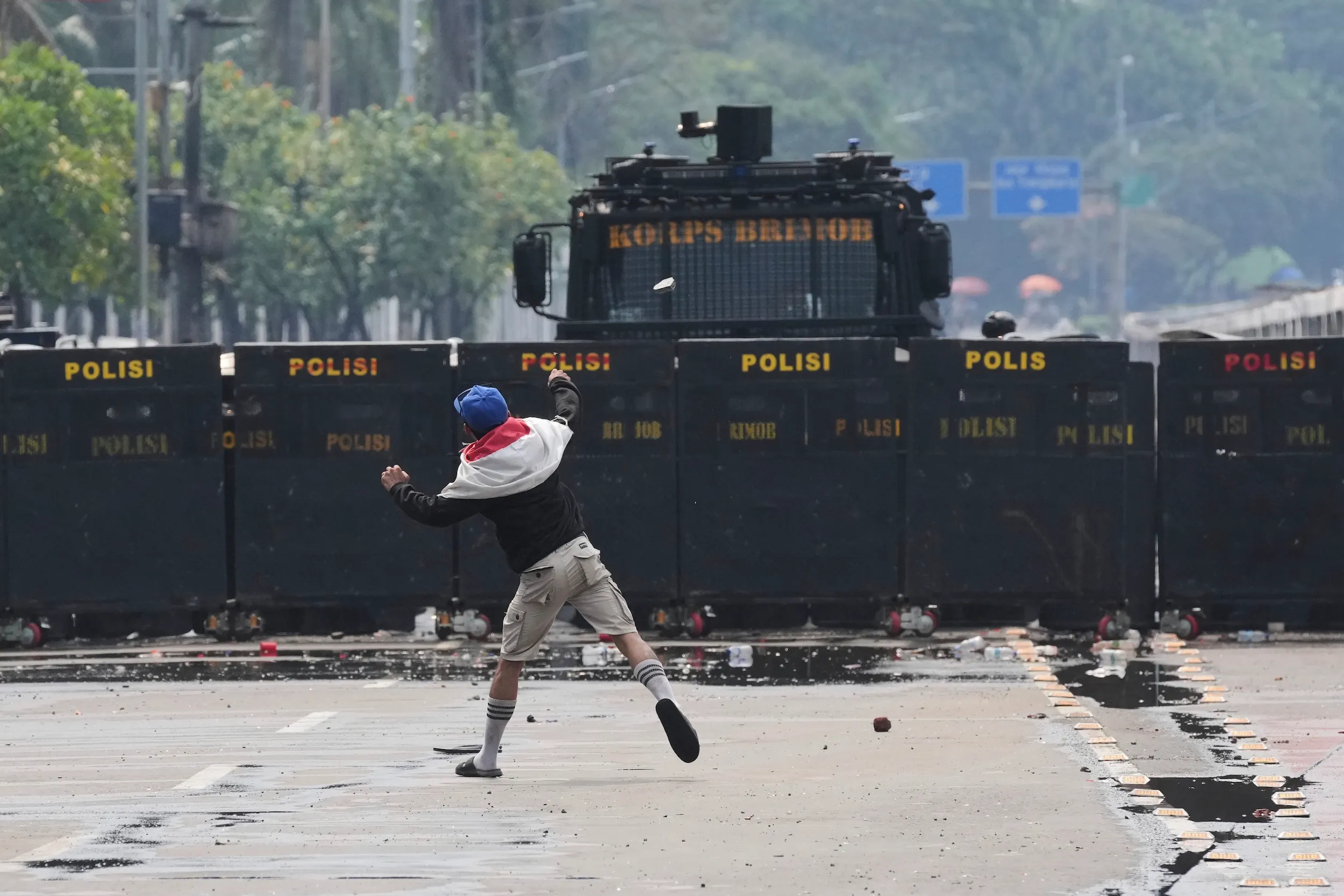 2025年8月31日、インドネシアのジャカルタ議会外で警察に向けて石を投げる抗議者。（AP通信）