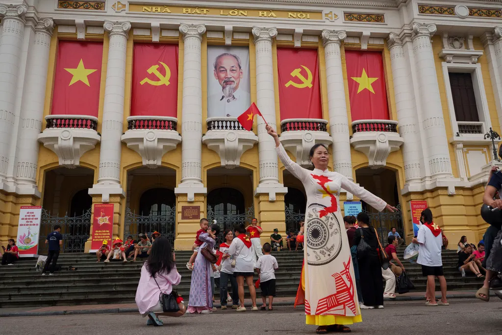 越南民眾揮舞國旗，並穿戴各種國徽或特別圖騰象徵上街，慶祝獨立80週年。（美聯社）