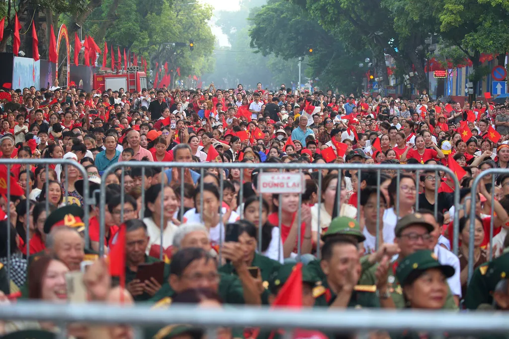 越南民眾揮舞國旗，並穿戴各種國徽或特別圖騰象徵上街，慶祝獨立80週年。（美聯社）