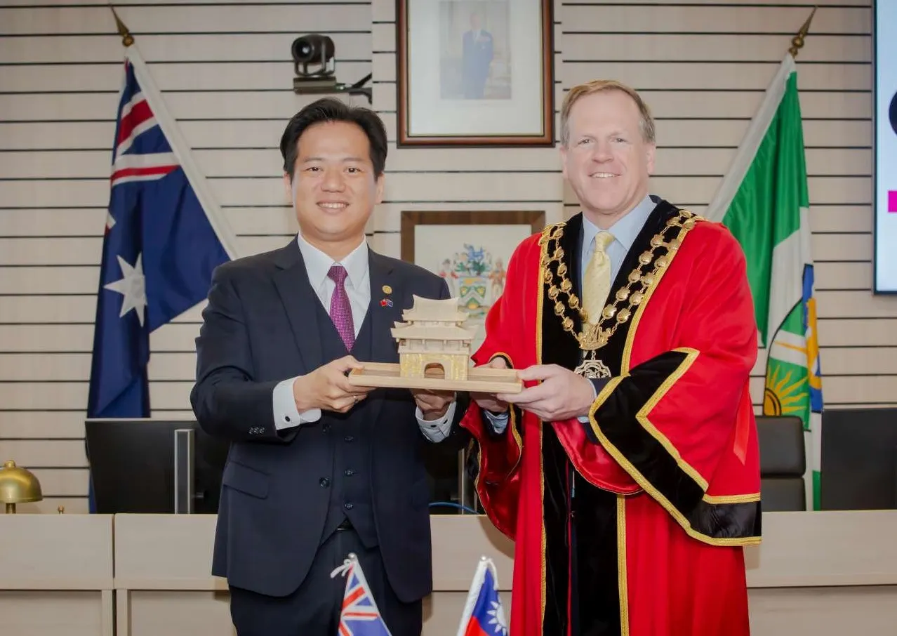 竹市代理市長邱臣遠致贈東門城石雕予萊德市長Trenton Brown。（圖／新竹市政府提供）