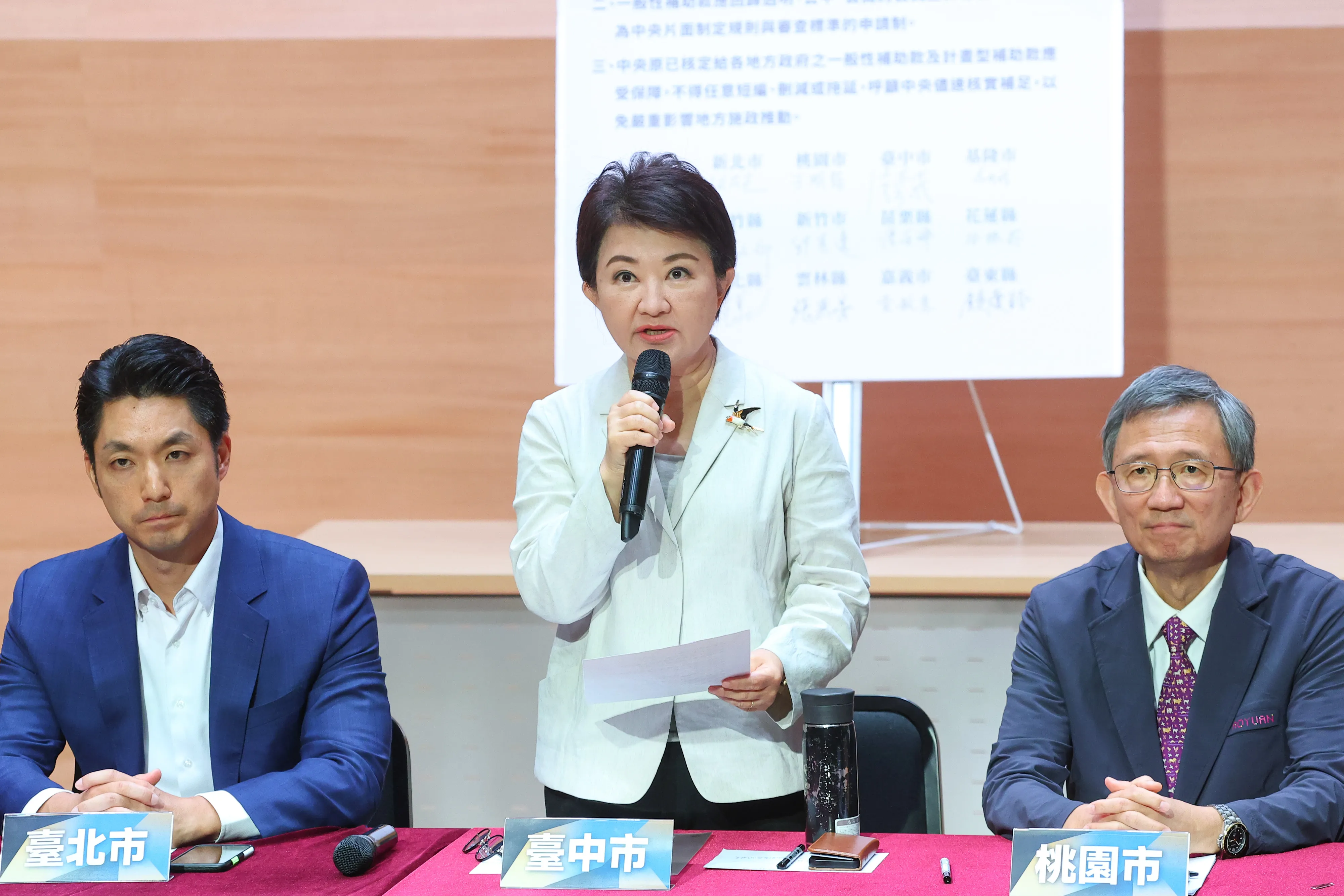 20250910-台中市長・盧秀燕（中）、桃園市副市長・王明鉅（右）、台北市長・蒋万安（左）等のブルー及びホワイトの県市長、副市長が日本時間10日に出席した「十五県市・あるいは自ら守る地方補助」記者会見。（顏麟宇撮影）
