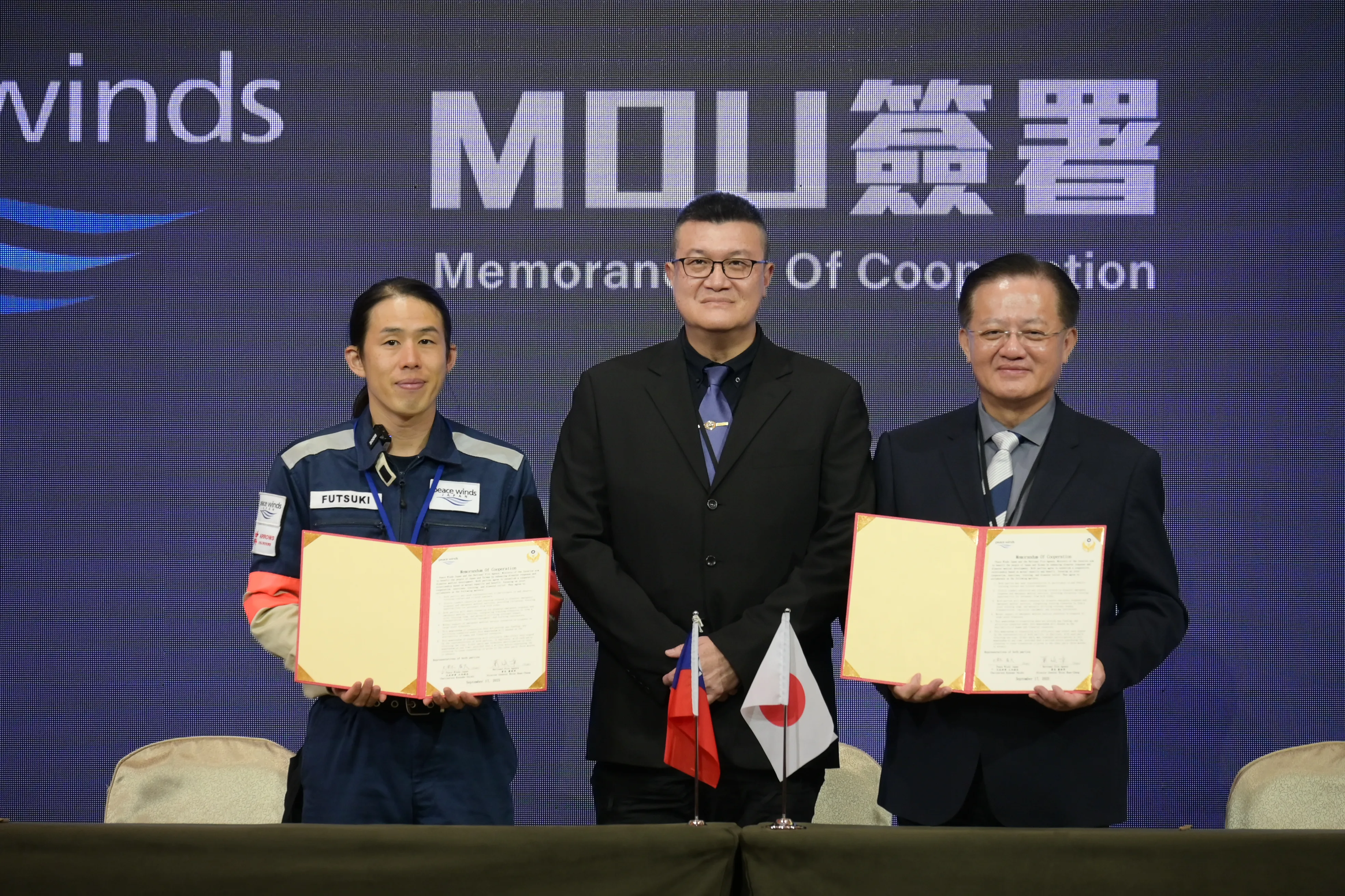 20250917-內政部政務次長馬士元（中）17日見證消防署長蕭煥章（左）與國際人道救援組織日本「和平之風」代表簽署合作備忘錄。（內政部提供）