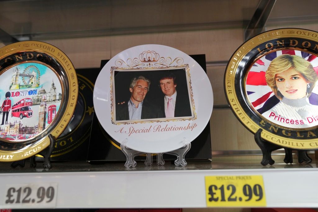 2025年9月12日。抗議組織「 Everyone Hates Elon」的一位活動家將印有美國總統川普和艾普斯坦照片的盤子放在禮品店的架上。(AP）