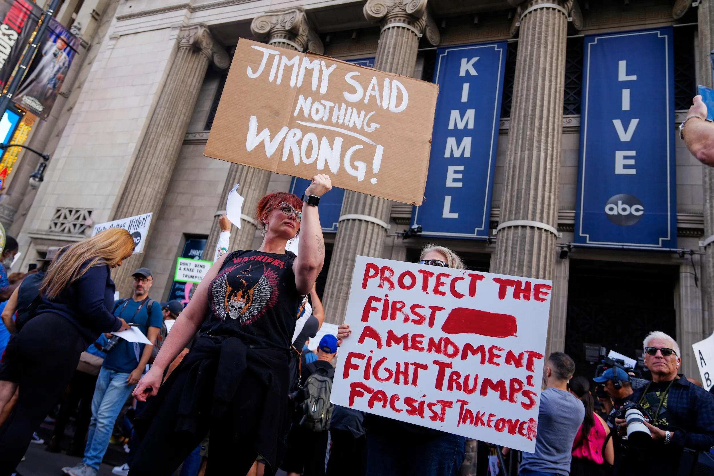 2025年9月18日，示威者於在洛杉磯的埃爾卡皮坦娛樂中心外高舉支持金摩的標語牌，此處是深夜節目《吉米·金摩現場秀》的錄製地點。（美聯社）
