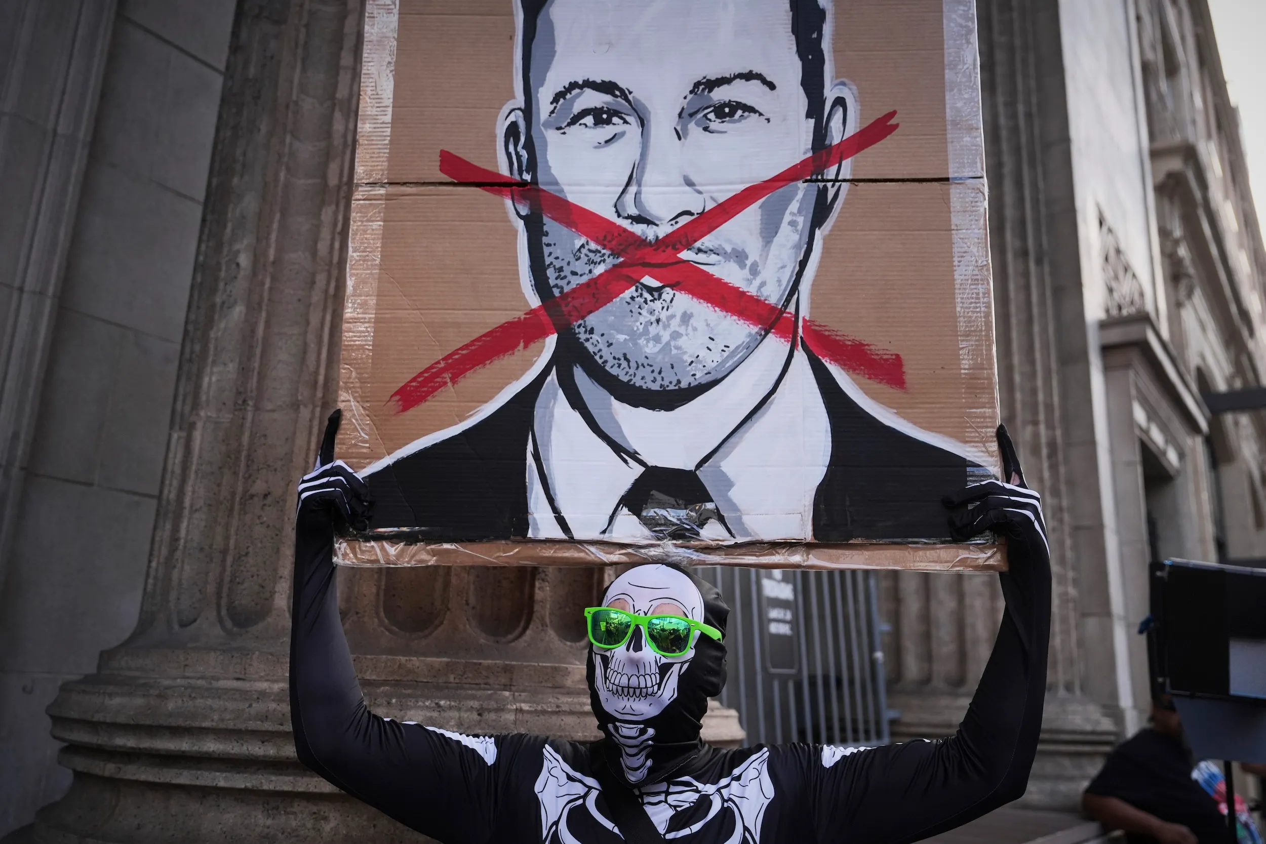 2025年9月18日，一名示威者於在洛杉磯的埃爾卡皮坦娛樂中心外舉著標語牌，此處是深夜節目《吉米·金摩現場秀》的錄製地點。（美聯社）