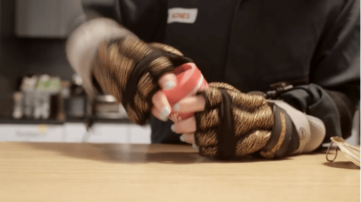 身穿年齡模擬服的Amy Marcus試著打開一罐湯。（華爾街日報）