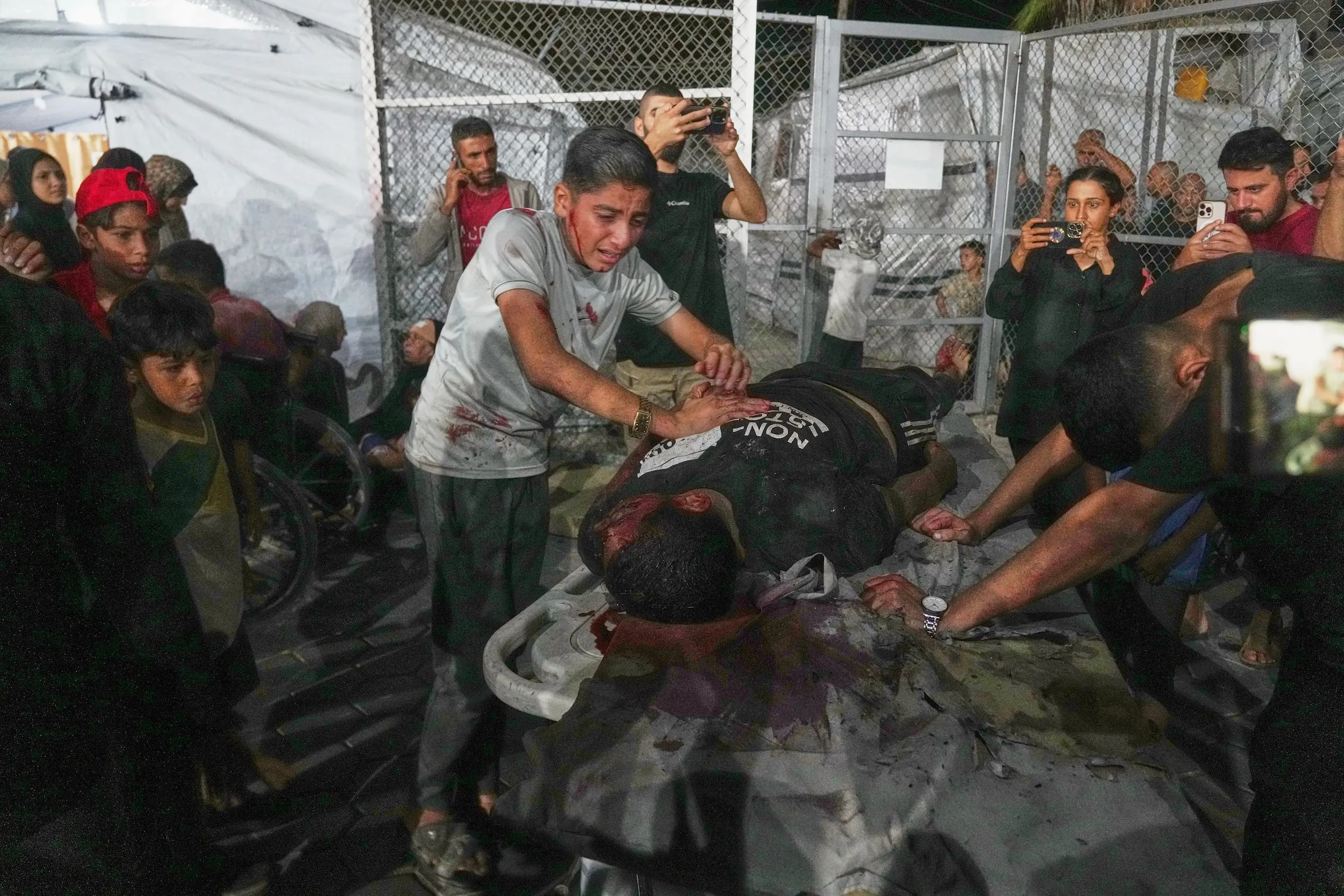 2025年9月30日，加薩中部迪爾巴拉（Deir al-Balah），一名受傷男孩在阿克薩醫院為一名死者痛哭。該男子死於以軍對一家木工廠與咖啡館的空襲，遺體被送入醫院。（美聯社）