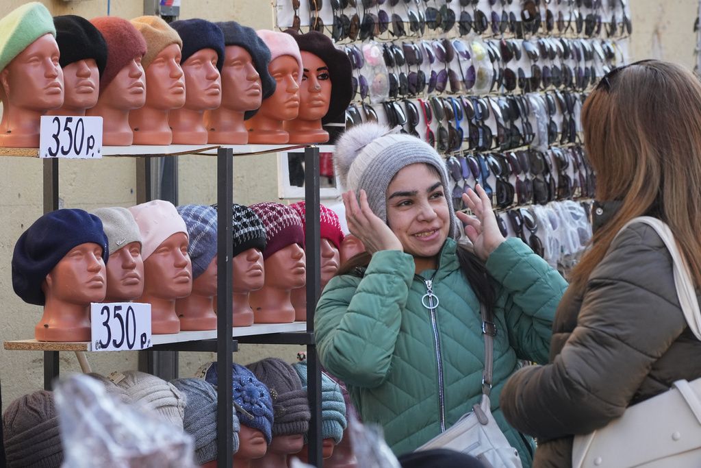 2025年10月1日。一人の女性がロシアのサンクトペテルブルク市場で帽子を選ぶ。（AP）