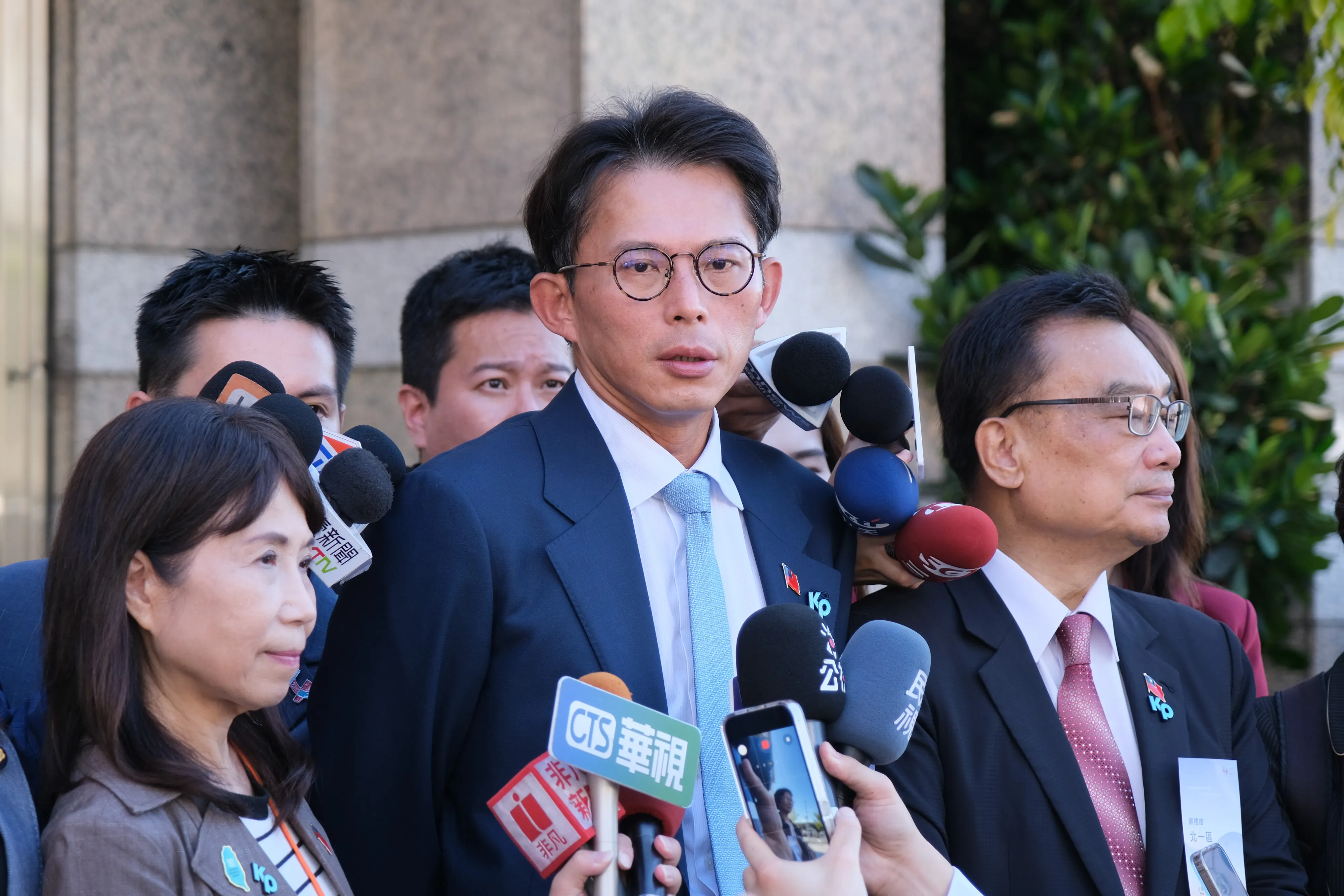 20251010-114年国慶大会10日、大統領府前で開催され、台湾民衆党主席の黄国昌（中）と台湾民衆党のメンバーが国発会の建物前でインタビューを受けた。（劉偉宏撮影）