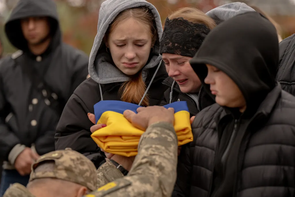 烏克蘭軍隊替因戰爭喪命的官兵覆蓋國旗舉行葬禮。（美聯社）