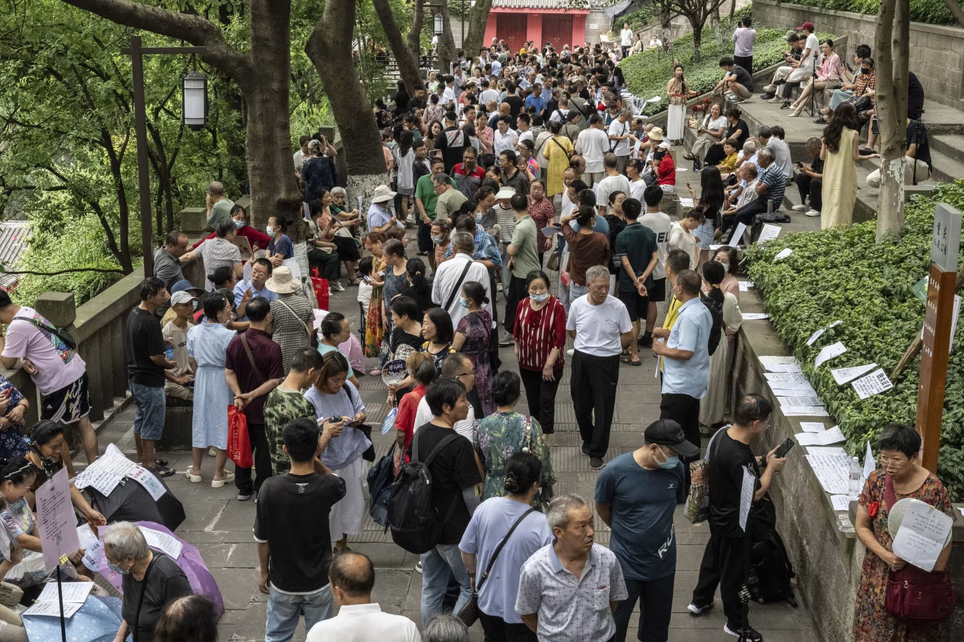 人民公園的相親角有時擁擠不堪，以老年人為主的人群不得不在步道上挪動，瀏覽一份份個人資料。（華爾街日報）