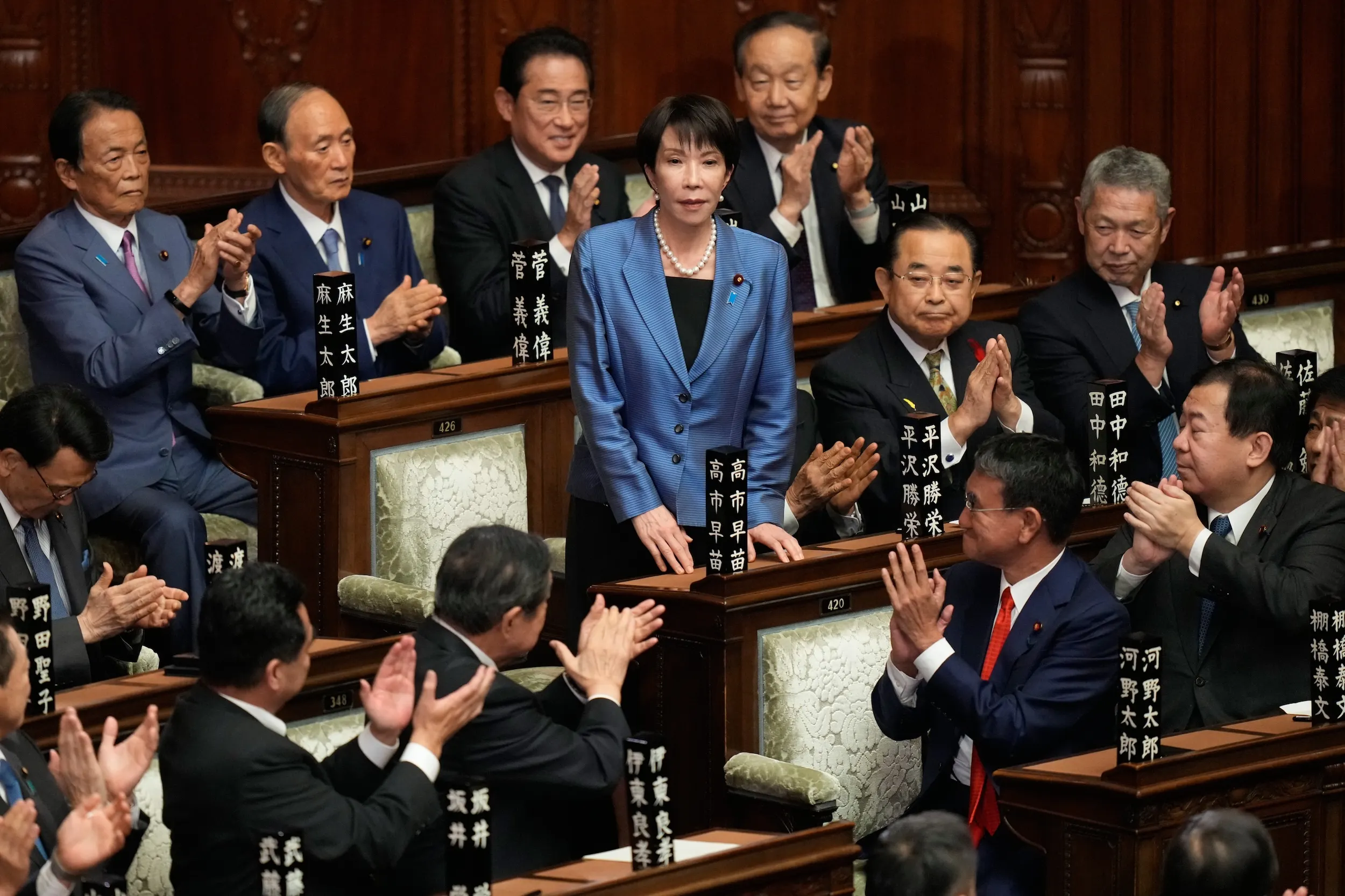 2025年10月21日，日本東京國會下議院臨時會上，眾議員起立鼓掌，慶賀高市早苗（中）當選日本新任首相。（美聯社）