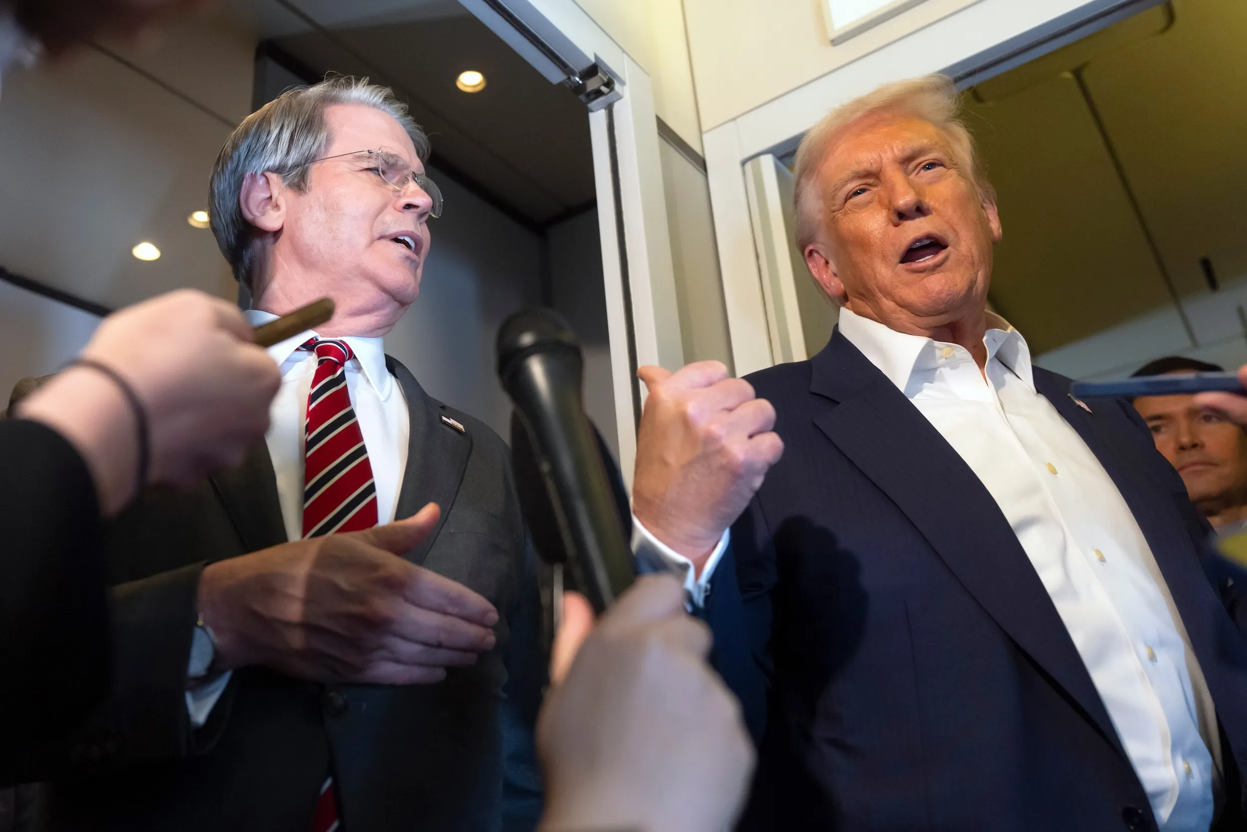 2025年10月27日，美國總統川普搭機前往日本時接受媒體訪問，一旁是財政部長貝森特。（美聯社）