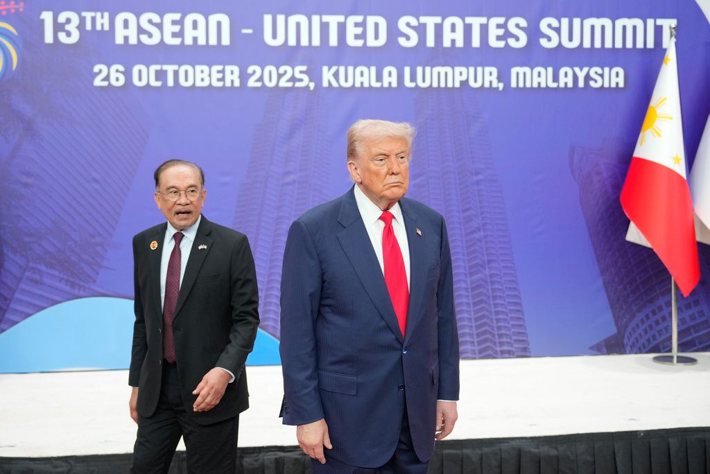 川普（右）出席由馬來西亞主辦的東協高峰會，左邊是今年輪值主席的首相安華。（美聯社）
