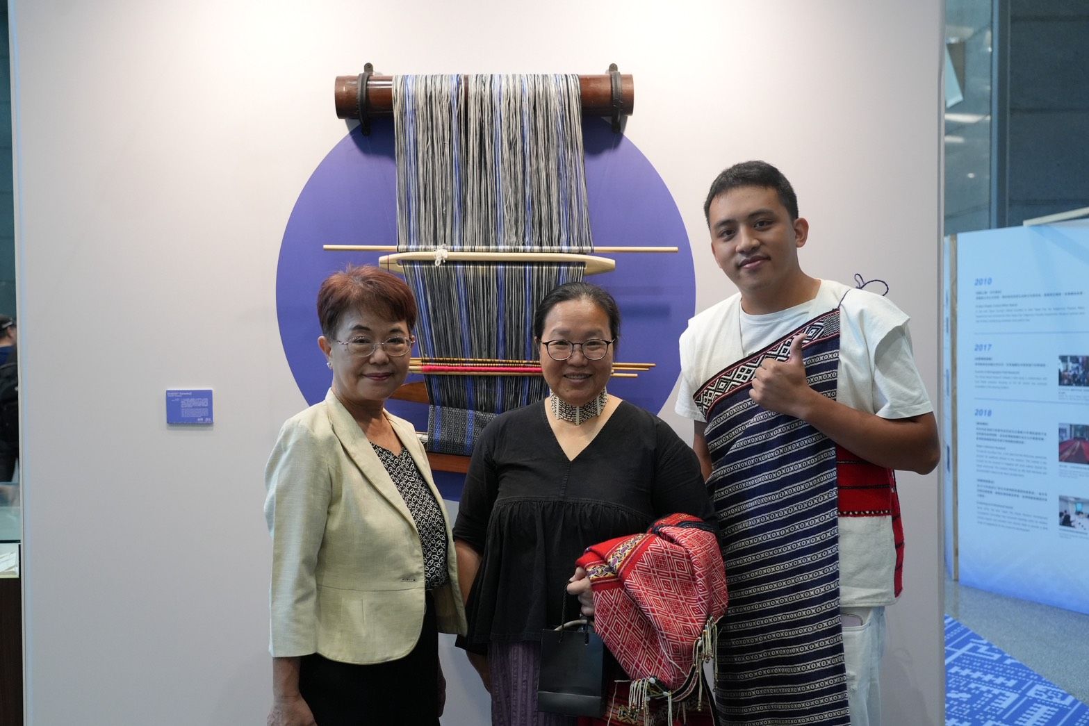 人間國寶尤瑪·達陸與作品【046387 Gewebe】合照。(圖/新北市政府原民局提供)。