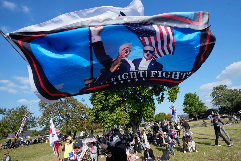 美國總統川普抵達南韓，支持派民眾上街揮舞旗幟歡迎。（美聯社）