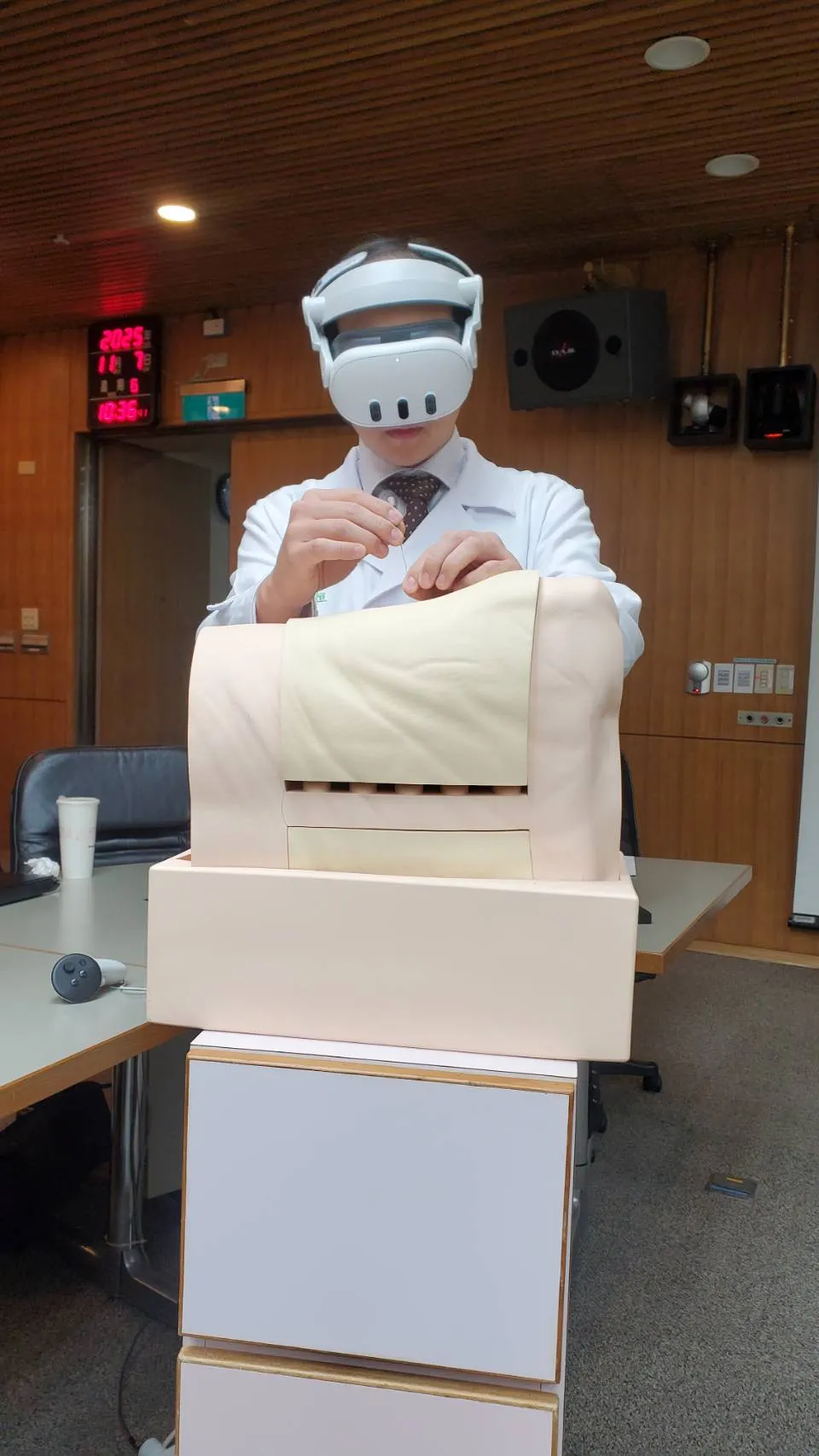 20251107-醫師戴著VR虛擬實境眼鏡，模擬在數位孿生的實境中，以探計尋找病兆定位的情況。（黃天如攝）