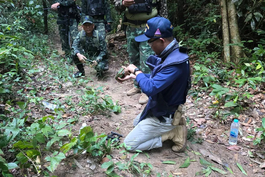 2025年11月10日。一名泰國官員在泰國－柬埔寨邊境附近檢查地雷。（Royal Thai Army via AP）