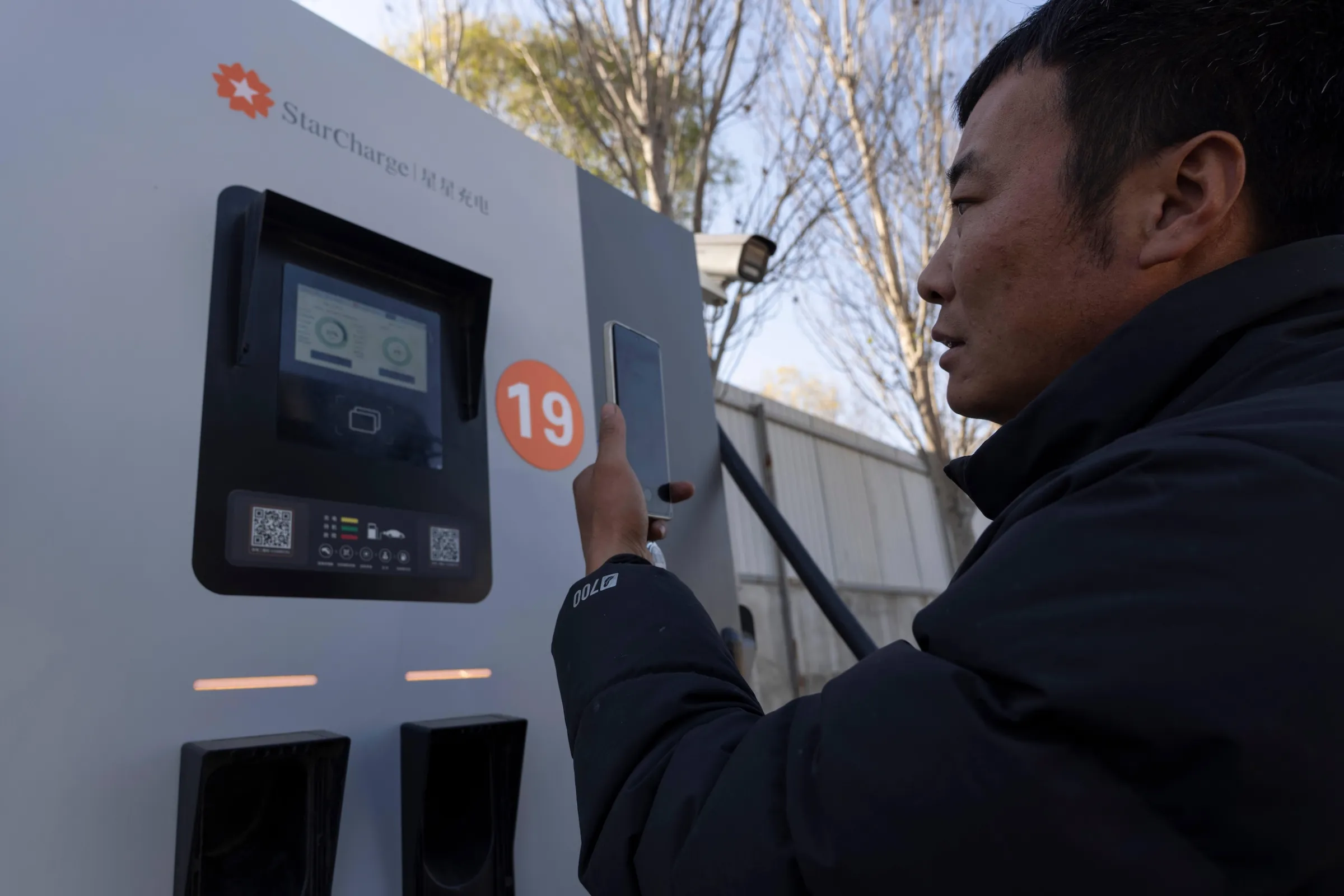 2025年11月14日，北京一名貨車司機在充電站為他的電動卡車充電。（美聯社）