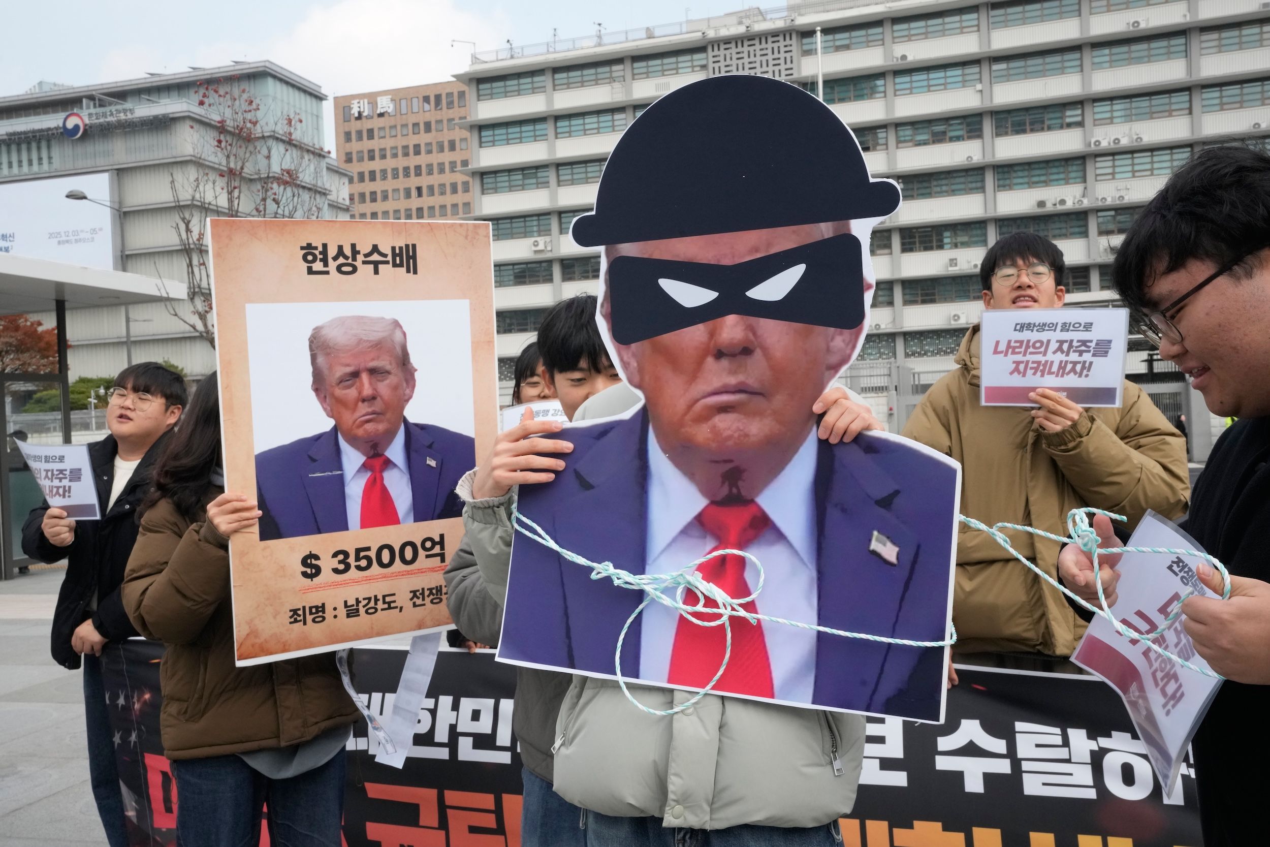 2025年11月20日、韓国の学生らがアメリカ大使館の近くでトランプ大統領の韓国に対する関税政策に抗議し、「トランプを指名手配」と称して劇を上演した。（美聯社）