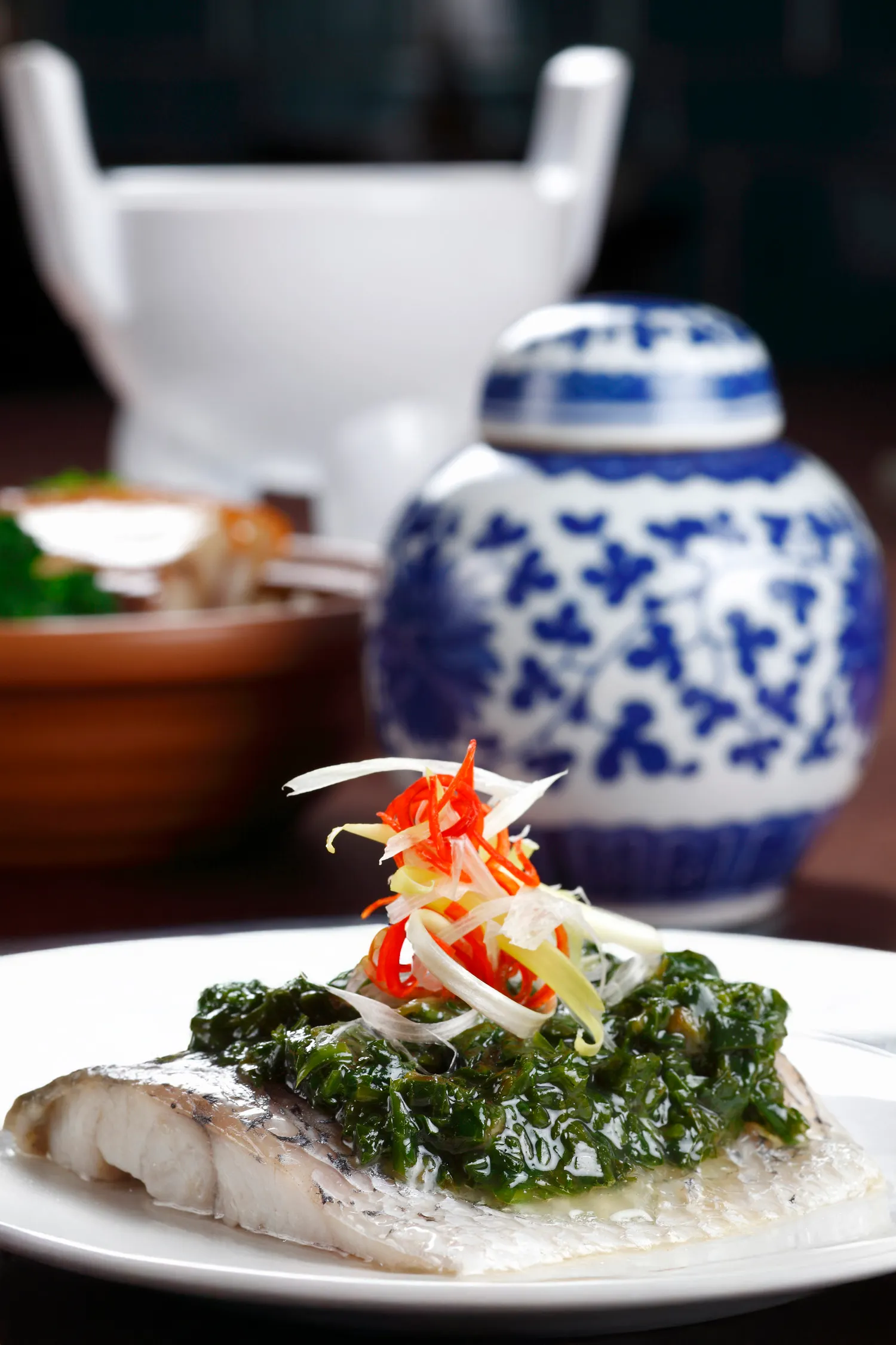 故宮晶華主廚以深受宋代文人喜愛的名菜--「金齏玉膾」為靈感，選用新鮮鱸魚切片清蒸，搭配鹹香爽脆的漬菜，重現千年前的清雅風味。(圖/台北晶華提供)