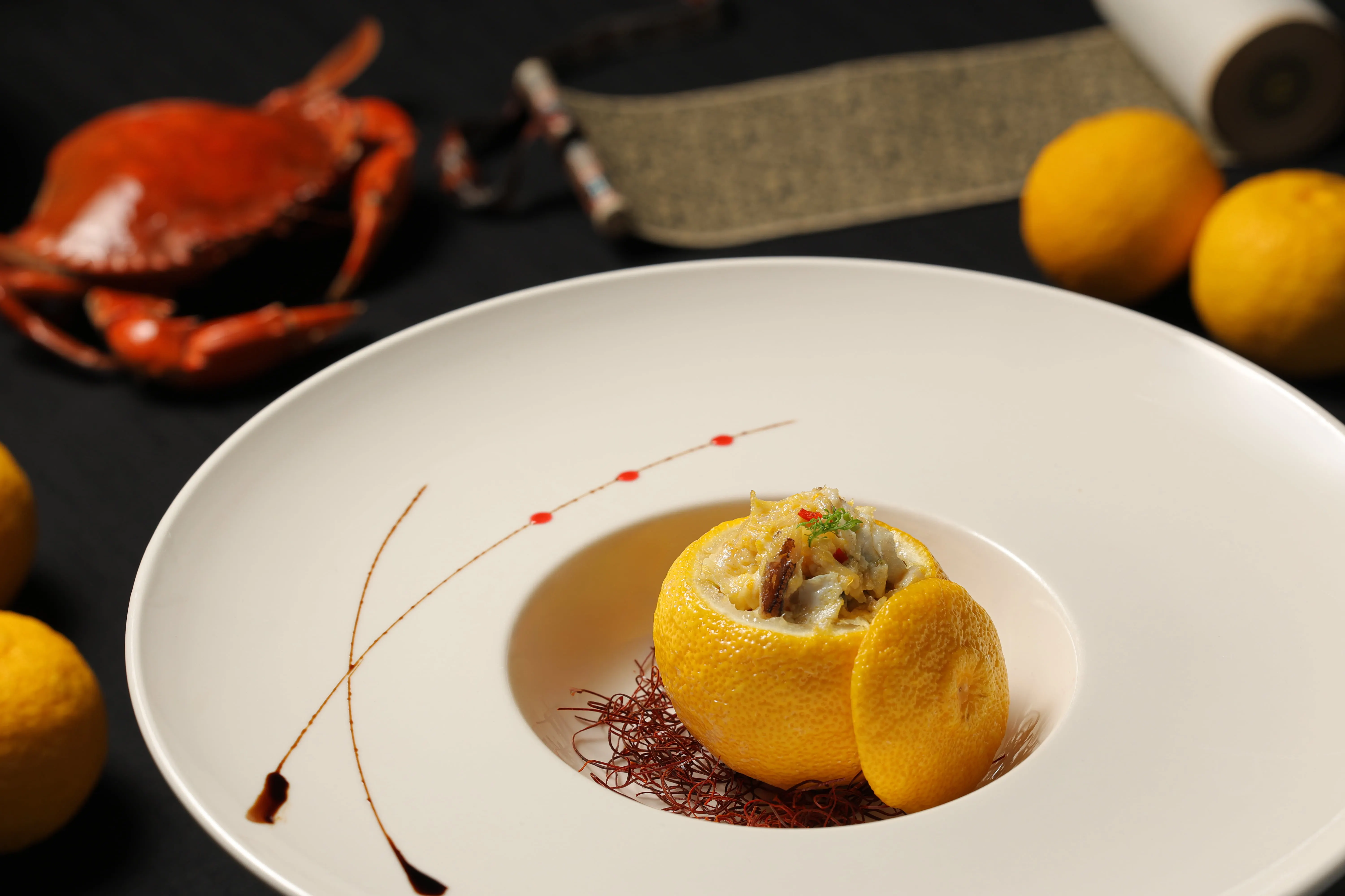 由故宮晶華推出的「大宋風華雅宴」套餐中，吸睛菜色包含讓宋孝宗愛不釋口的「蟹釀橙」，主廚在挖空的香橙中填入鑊氣滿滿的蟹料，果香與蟹香交融，香氣馥郁、滋味鮮美。(圖/台北晶華提供)