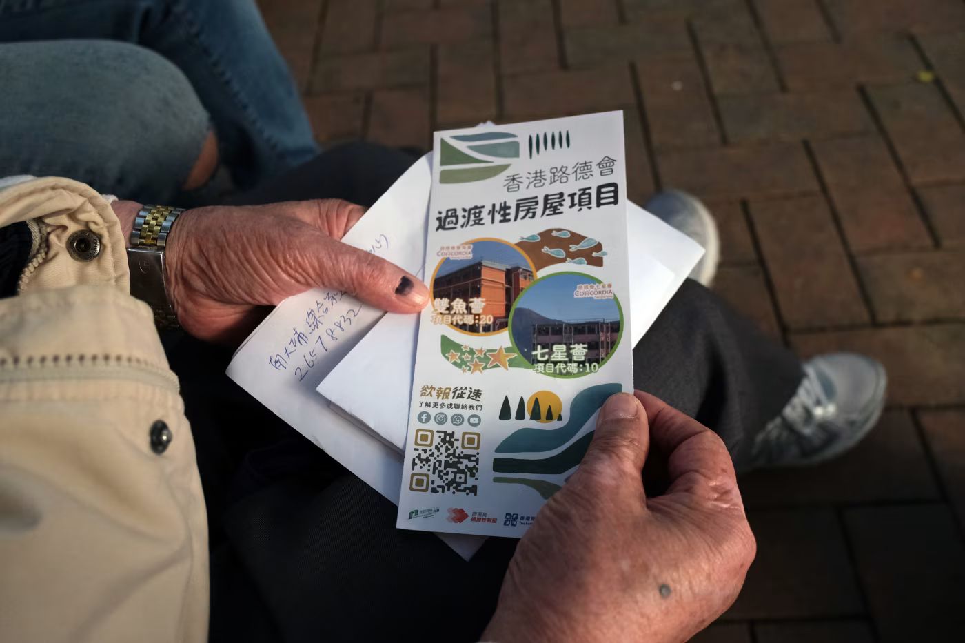 Chin Kwong-tak拿著介紹過渡住所的傳單。（圖片來源：The Wall Street Journal）