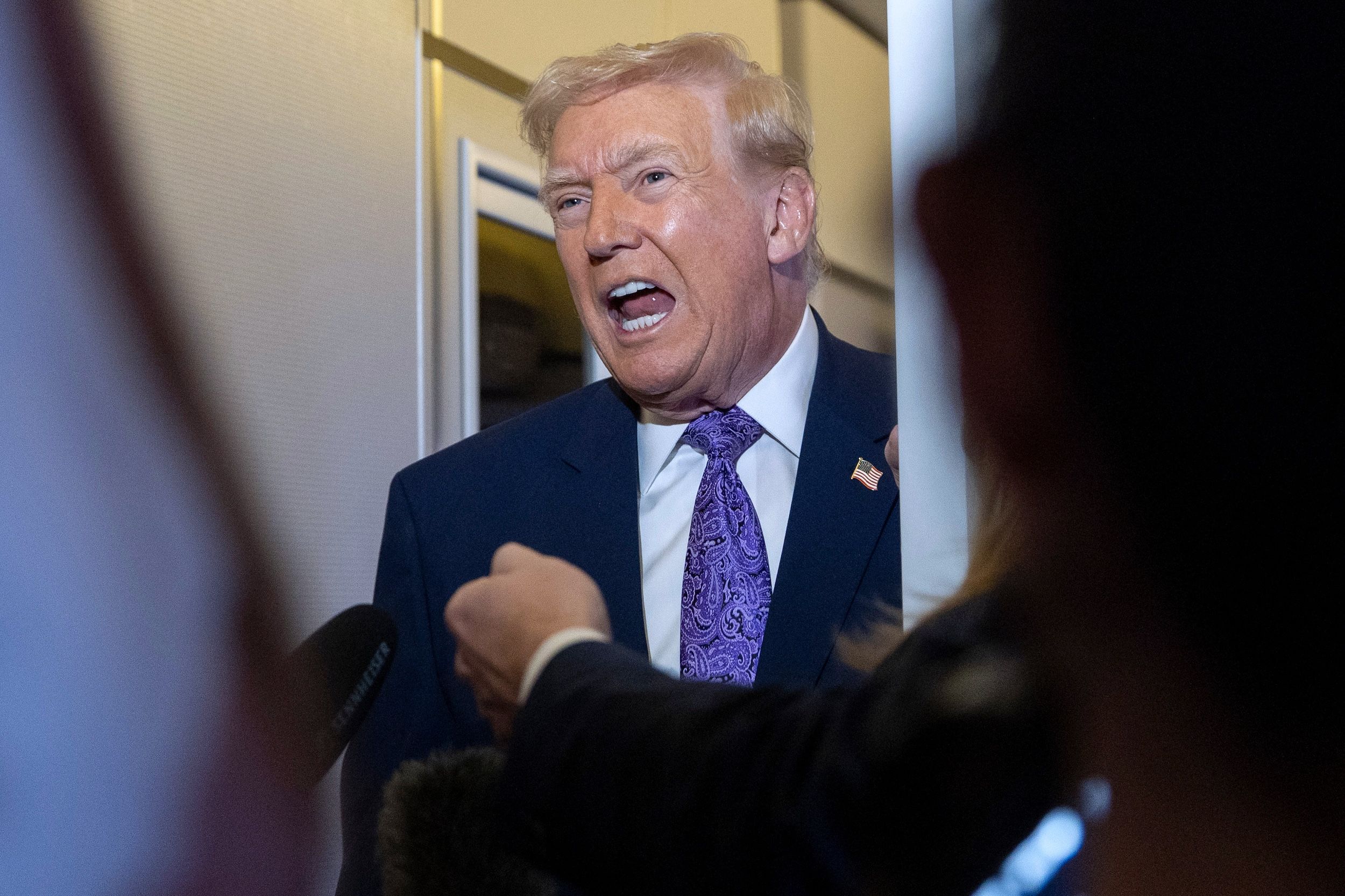 美國總統川普在總統專機空軍一號上與記者交談。（美聯社）