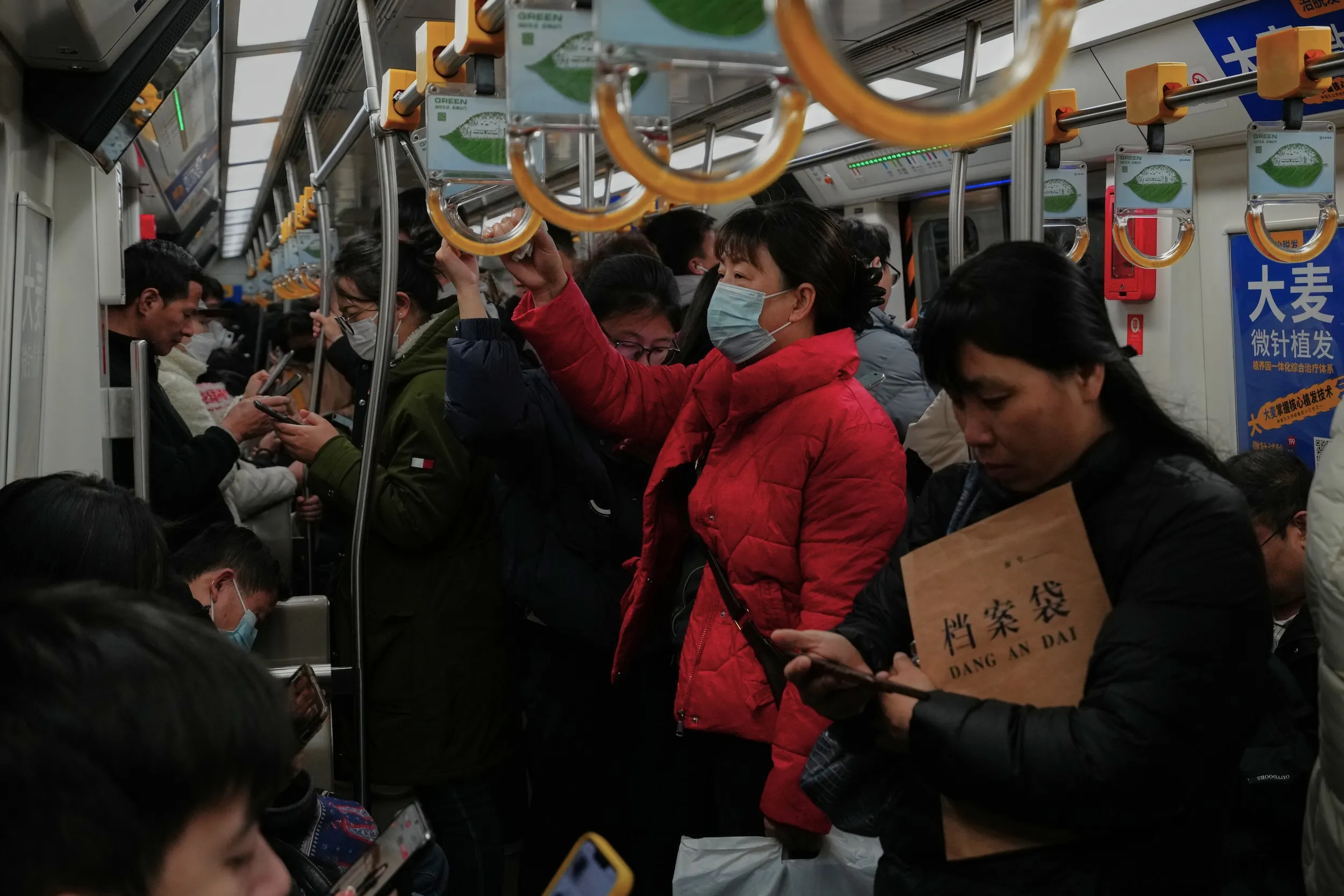 2025 年 12 月 1 日，北京午休時間，通勤族搭乘地鐵。（美聯社）