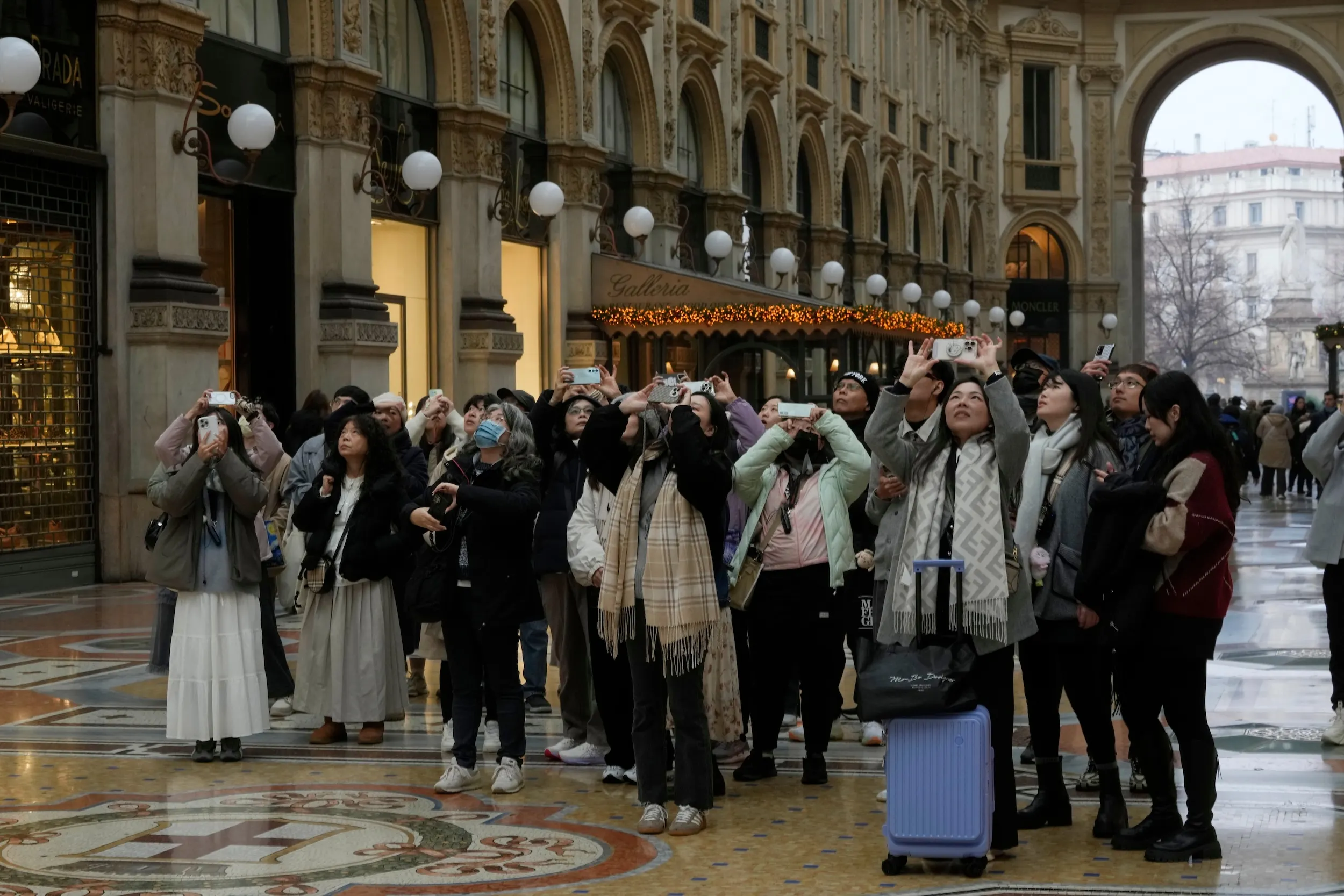 2025 年 12 月 2 日，義大利米蘭，一群亞洲遊客在艾曼紐二世迴廊拍照留念。（美聯社）