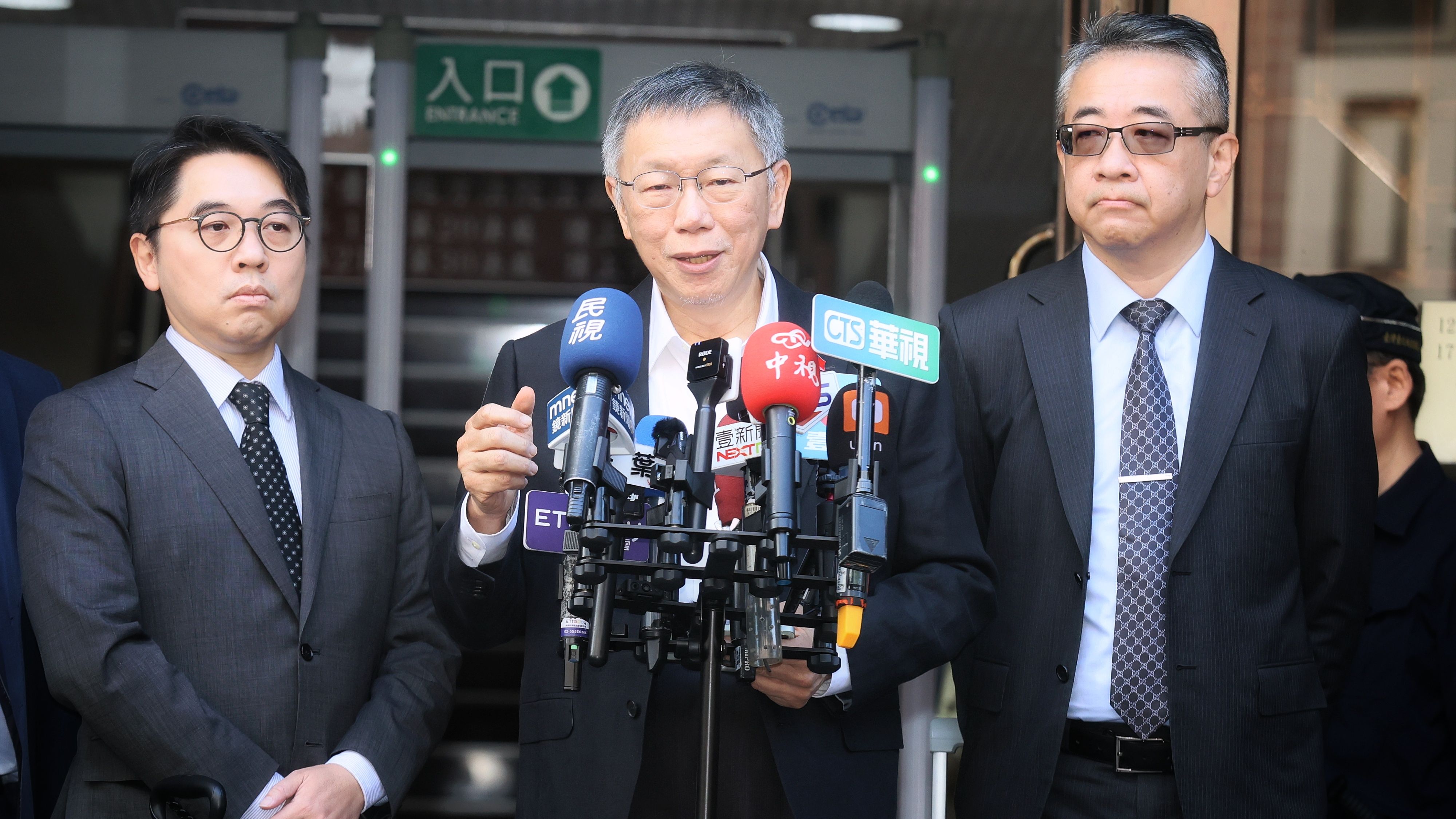 20251211-前台北市長柯文哲涉貪污案11日開庭，圖為開庭前柯文哲（中）在台北地院門前談話。（柯承惠攝）