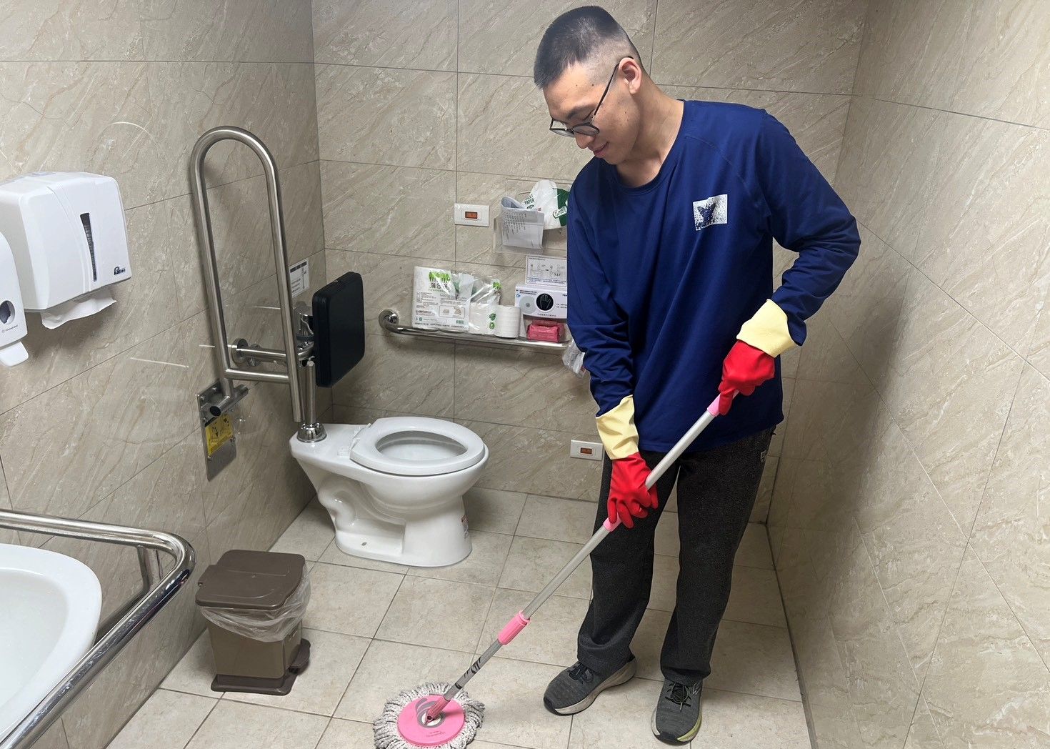 竹夢園的阿哲在就服員耐心引導下，從掃地、拖地到刮玻璃等技巧性工作，現已能在少許協助下完成各項清潔工作。（圖／新竹市政府提供）