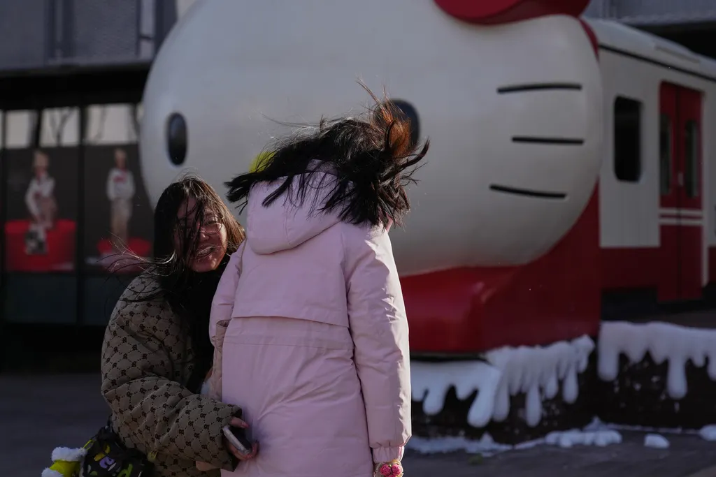 中國北京民眾路過一處凱蒂貓裝置藝術的商業街。（美聯社）