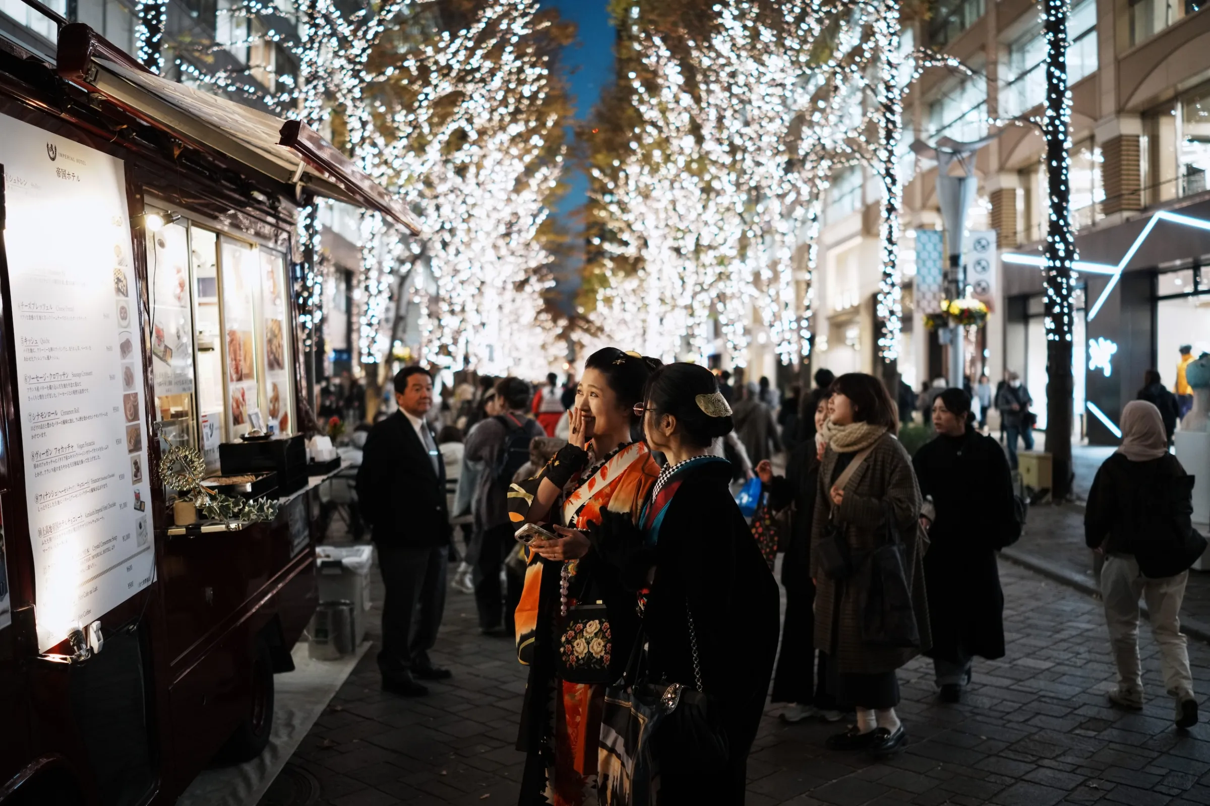 2025年12月10日，日本東京民眾漫步在佈滿冬季燈飾的丸之內仲通街頭。（美聯社）