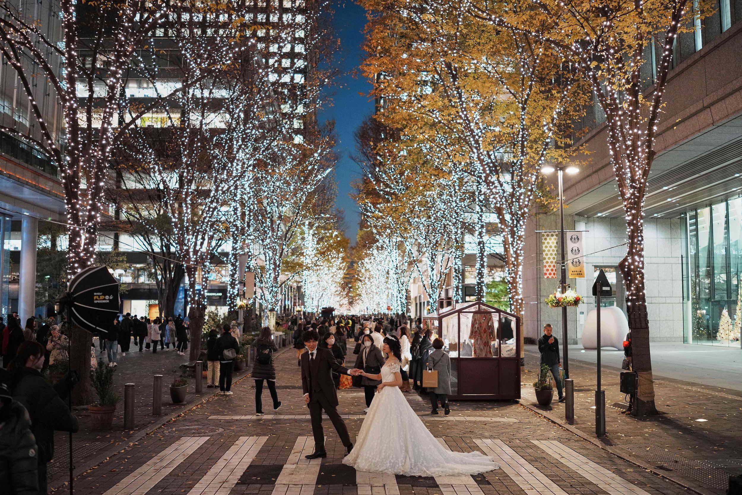 2025年12月10日，日本東京民眾漫步在佈滿冬季燈飾的丸之內仲通街頭。（美聯社）