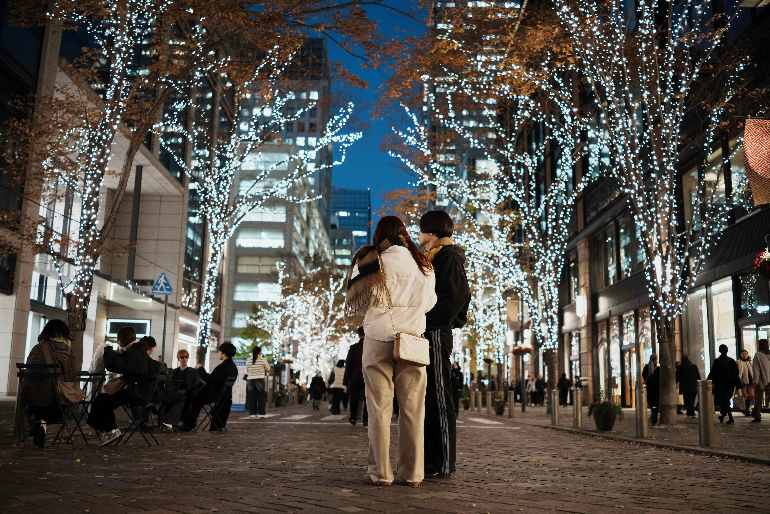 2025年12月10日，日本東京民眾漫步在佈滿冬季燈飾的丸之內仲通街頭。（美聯社）
