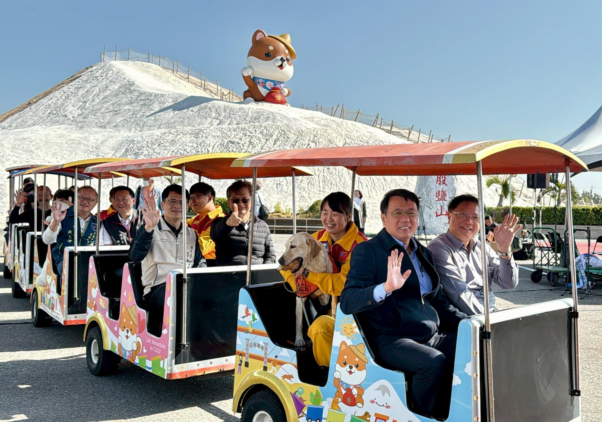臺鹽董事長丁彥哲（右8）、總經理李杰翰（右7）、觀光署雲嘉南風管處長徐振能（左6）、台南觀旅局副局長鄭道立（左5）等人齊聚七股鹽山，共同宣佈「鹹DOG DOG」正式亮相。（圖／臺鹽提供）